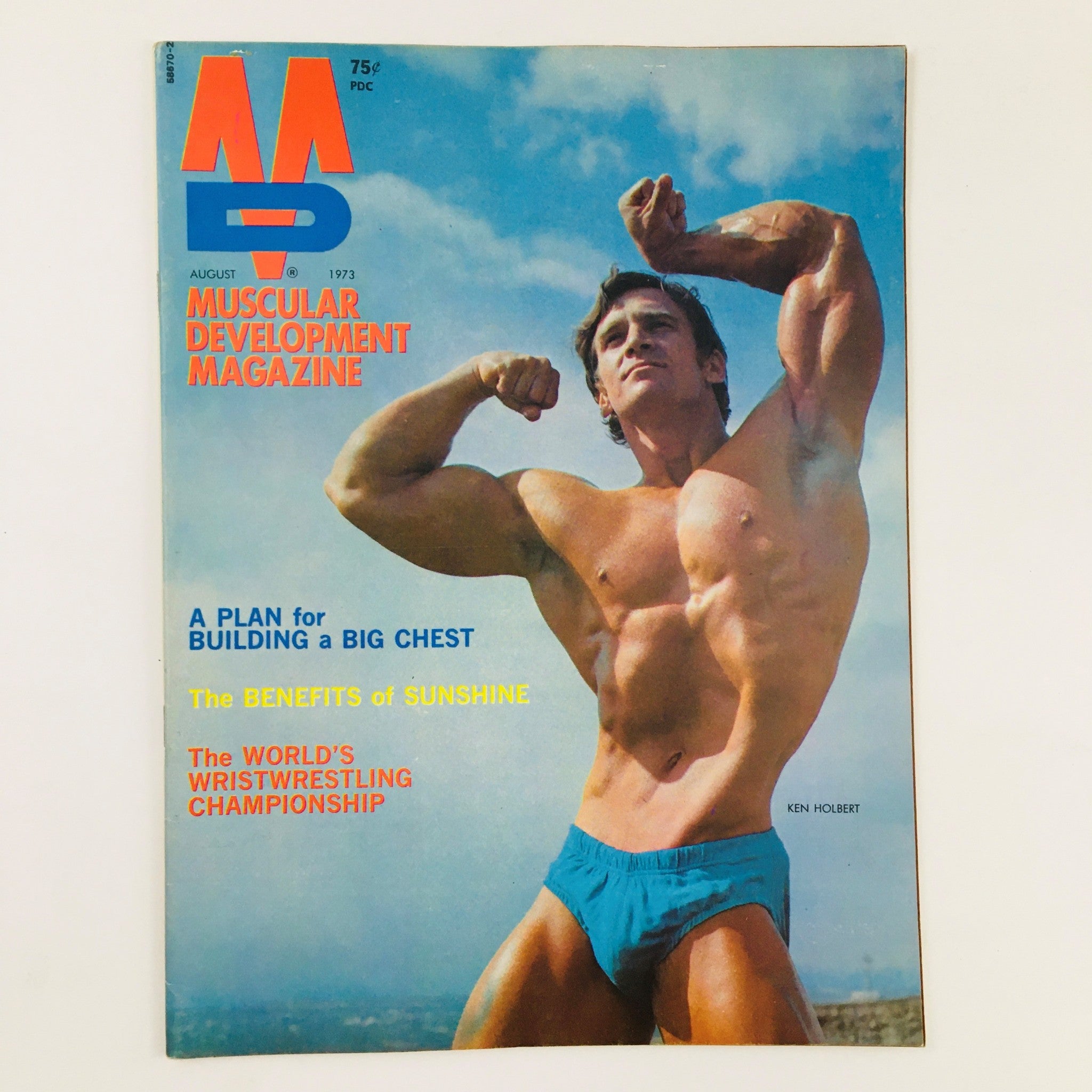 Cover of Muscular Development Magazine August 1973 featuring bodybuilder Ken Holbert showcasing strength and physique.
