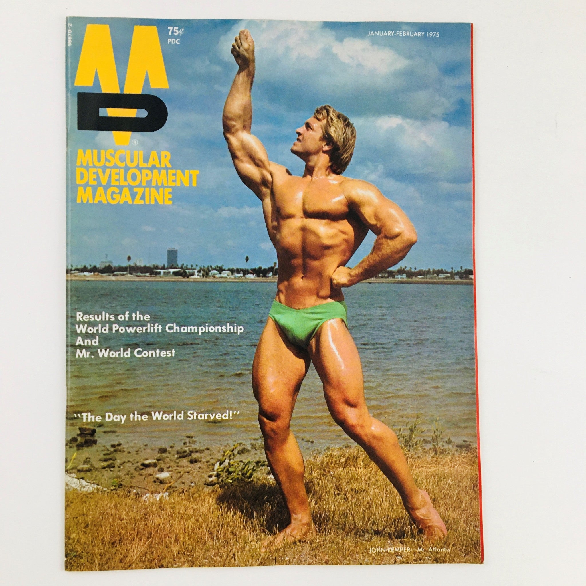 Cover of Muscular Development Magazine January 1975 showcasing a muscular man in a green swimsuit posing by the water, featuring the title and highlights on bodybuilding events.