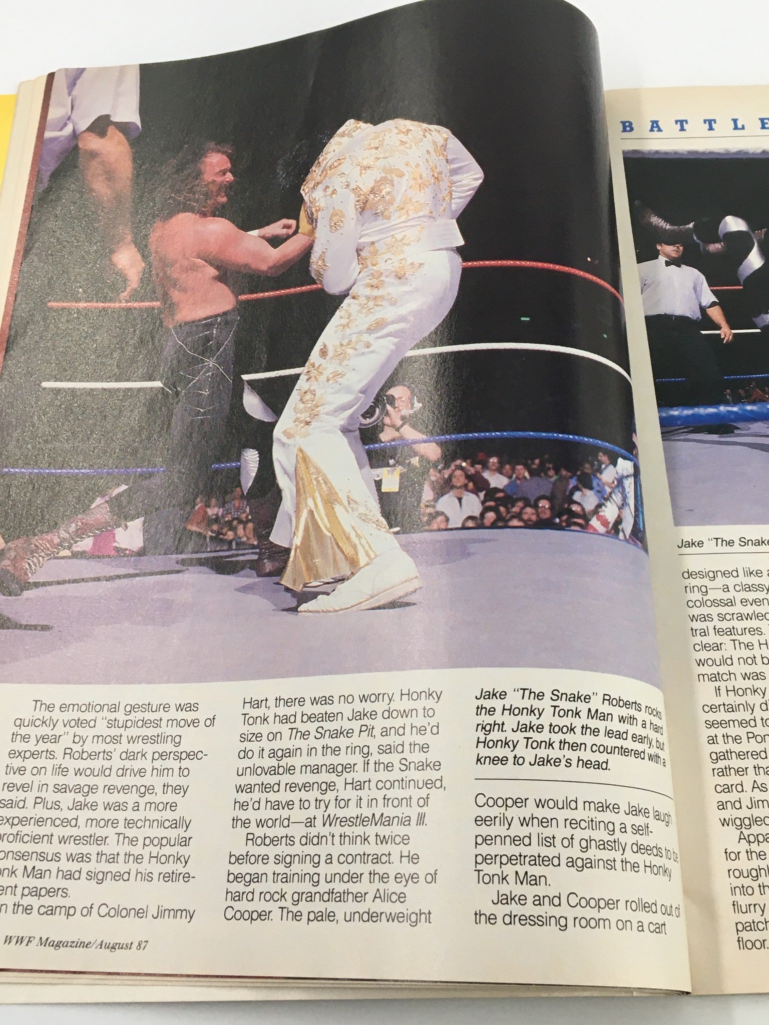 In-ring action captured in WWF Magazine August 1987 showing Jake 'The Snake' Roberts battling the Honky Tonk Man during a wrestling match.
