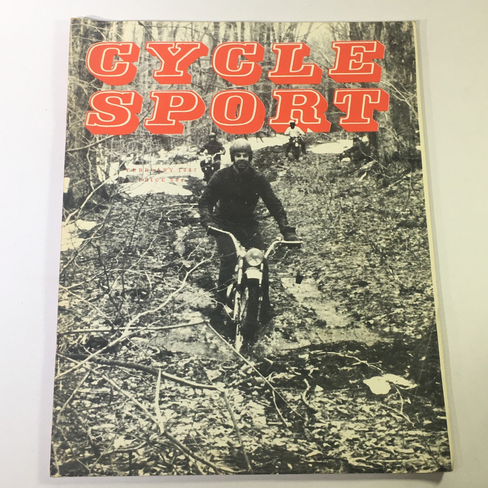 Cover of VTG Cycle Sport Magazine February 1967 featuring a vintage trail motorcyclist navigating through a muddy forest trail