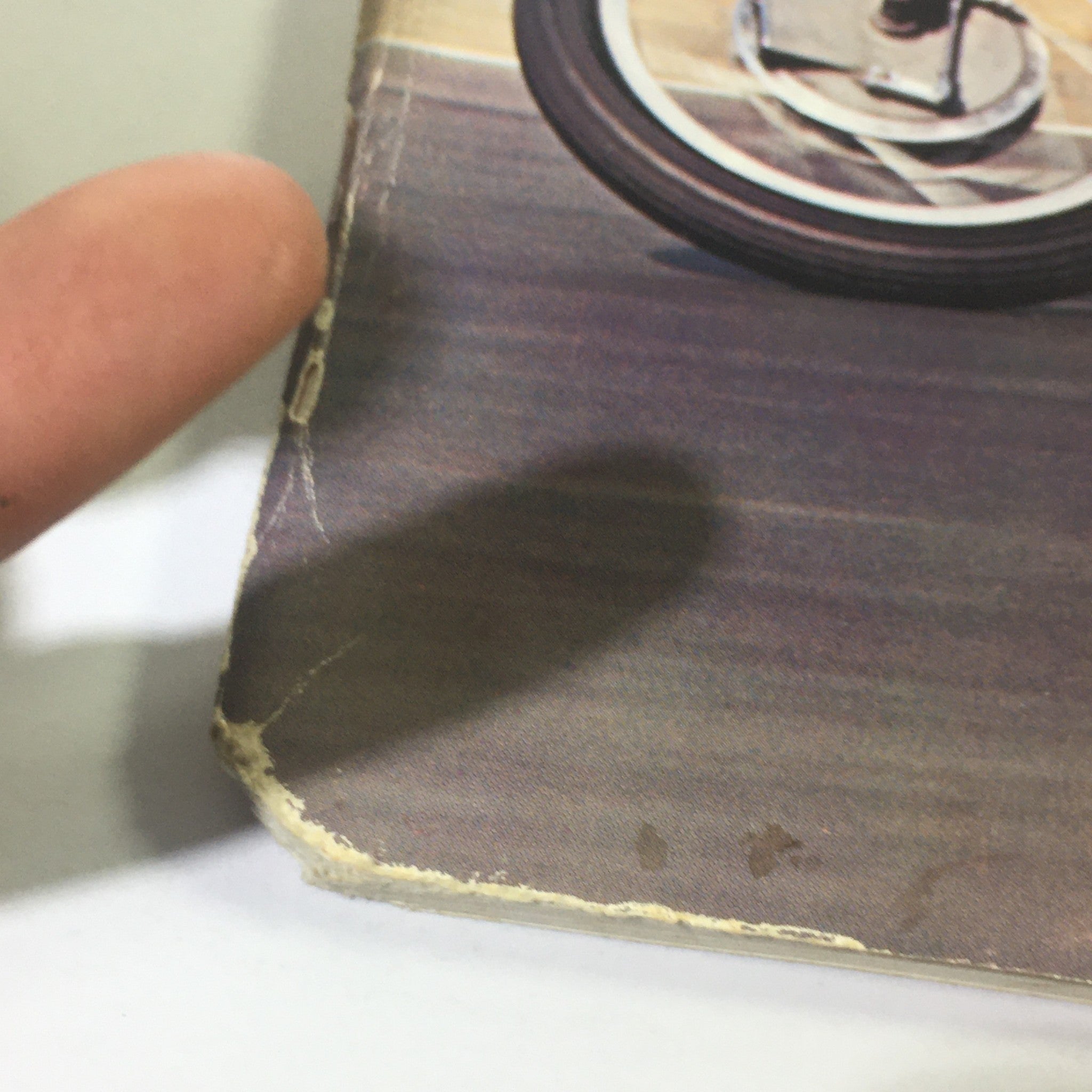 Close-up of the edge of VTG Cycle Sport Magazine August 1966, highlighting minor wear and tear, such as frayed edges and light damage, indicating its vintage condition.