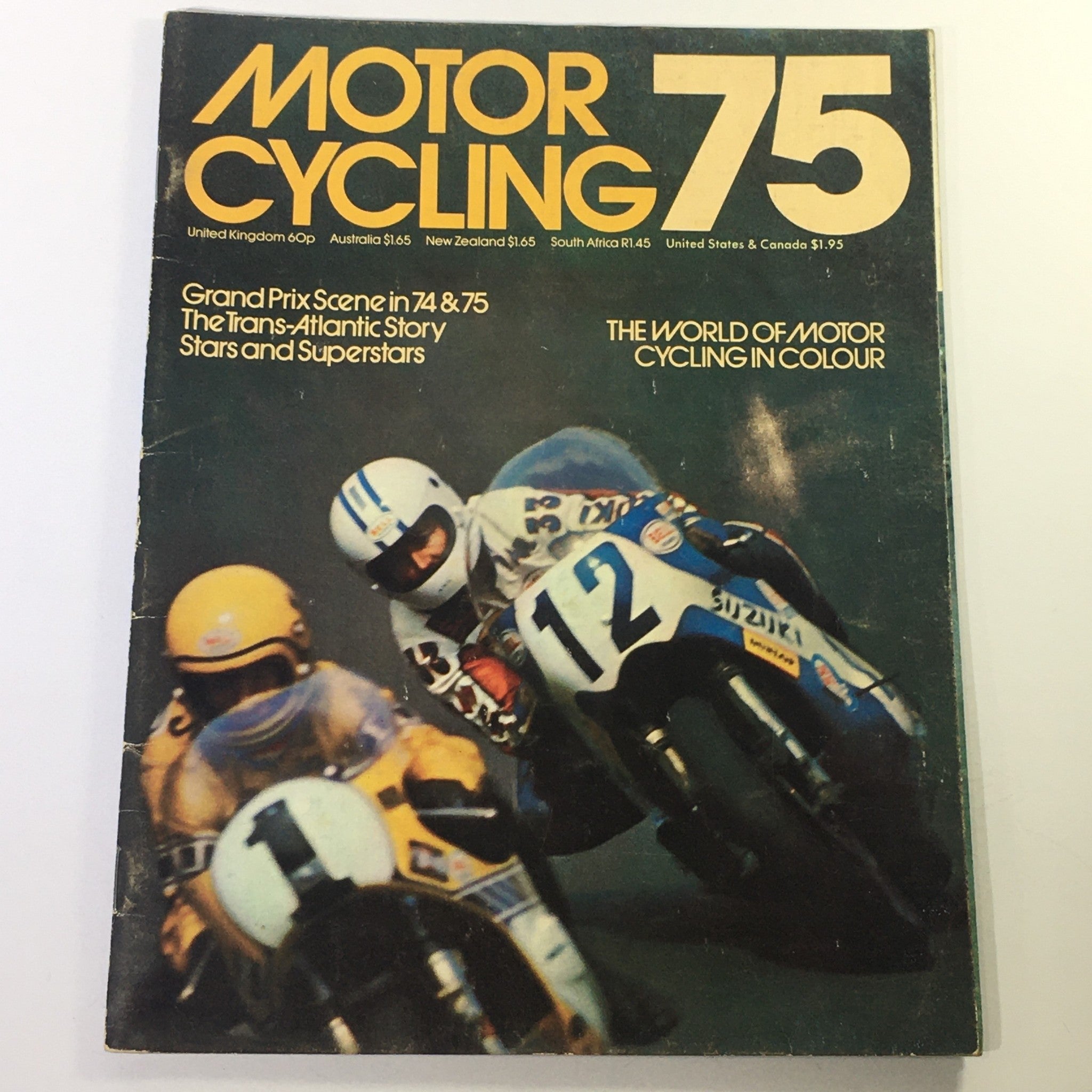 Cover of the Vintage Motor Cycling Magazine 1975 showcasing the Grand Prix Scene and Trans-Atlantic Story, featuring a dramatic motorcycle race with riders in vibrant gear.