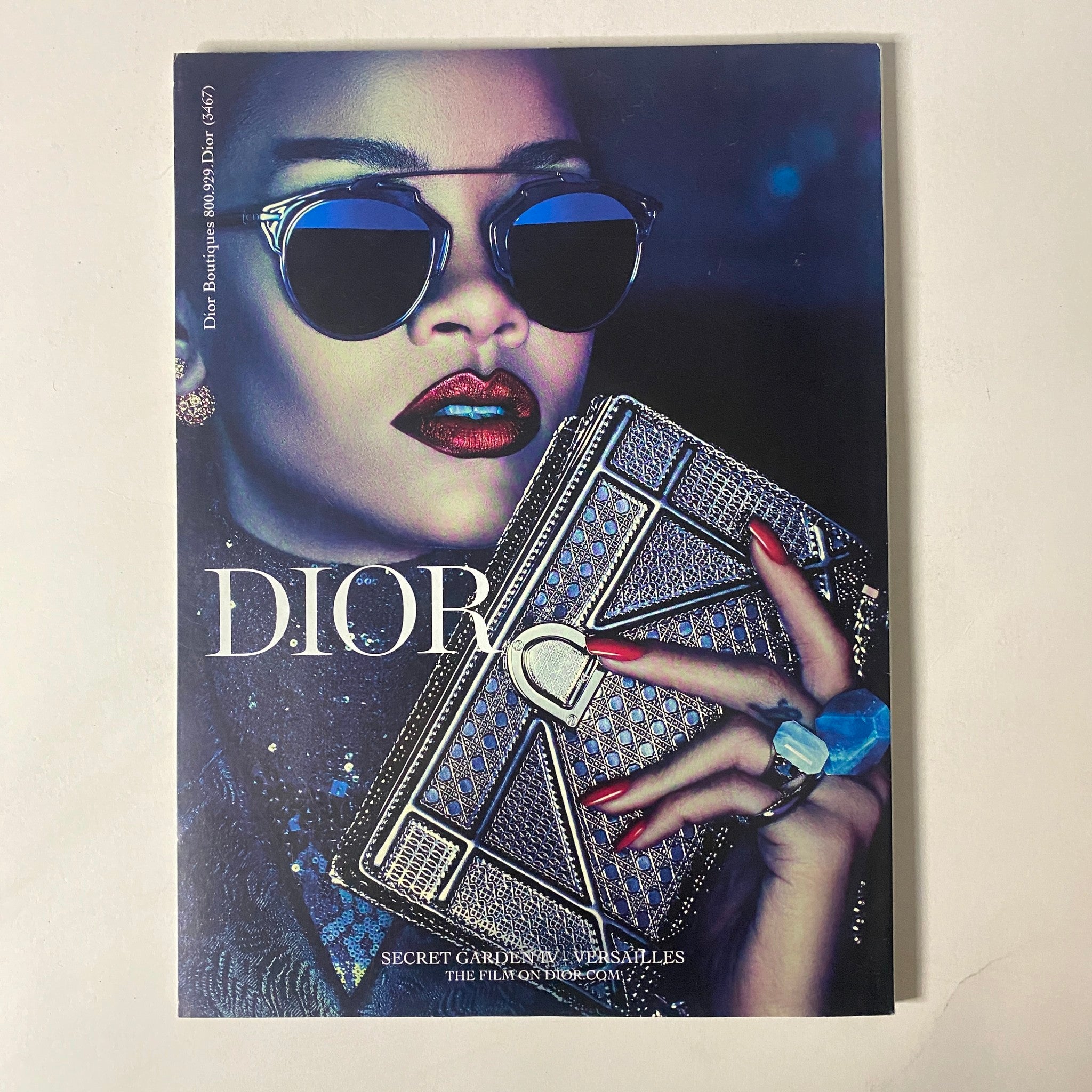 The cover of Dior's Secret Garden 2013 campaign magazine featuring a fashion model in sunglasses holding a stylish clutch. The image presents a striking visual aesthetic aligned with the chic fashion showcased in Vogue Magazine August 2015 with Nicole Kidman.