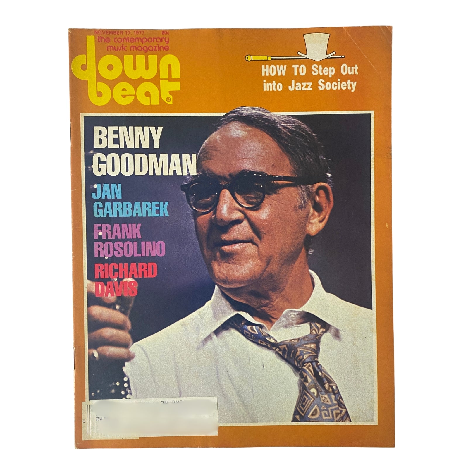 Cover of Down Beat Magazine, November 17, 1977, featuring Benny Goodman, Jan Garbarek, Frank Rosolino, and Richard Davis. The cover highlights Benny Goodman with a bright orange background and includes the title 'How To Step Out into Jazz Society'.