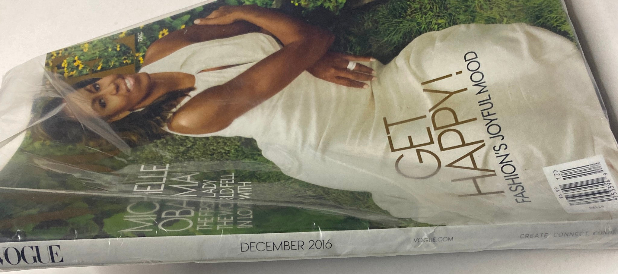 Close-up view of Vogue Magazine December 2016 featuring Michelle Obama, highlighting her in a serene pose and the text 'Get Happy! Fashion's Joyful Mood' prominently displayed.