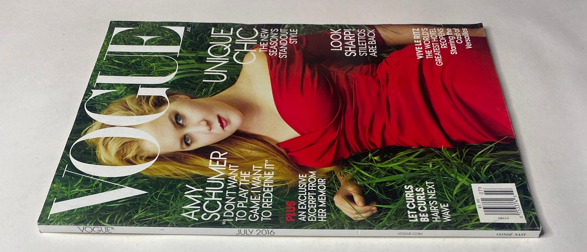 Another angle of the Vogue Magazine July 2016 cover with Amy Schumer, showcasing the magazine's title and the text 'Unique Chic'.