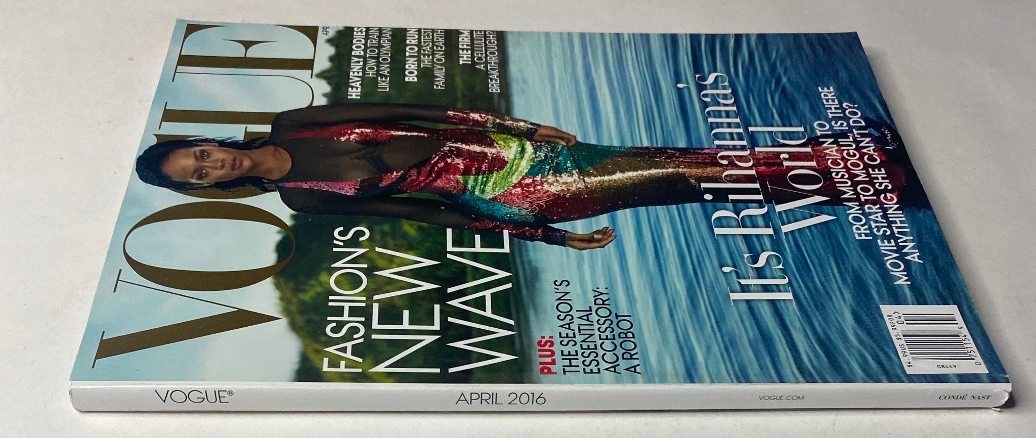 Another angle of the Vogue Magazine April 2016 cover with Rihanna in a vibrant dress, highlighting her feature story 'It's Rihanna's World' beneath the magazine logo.