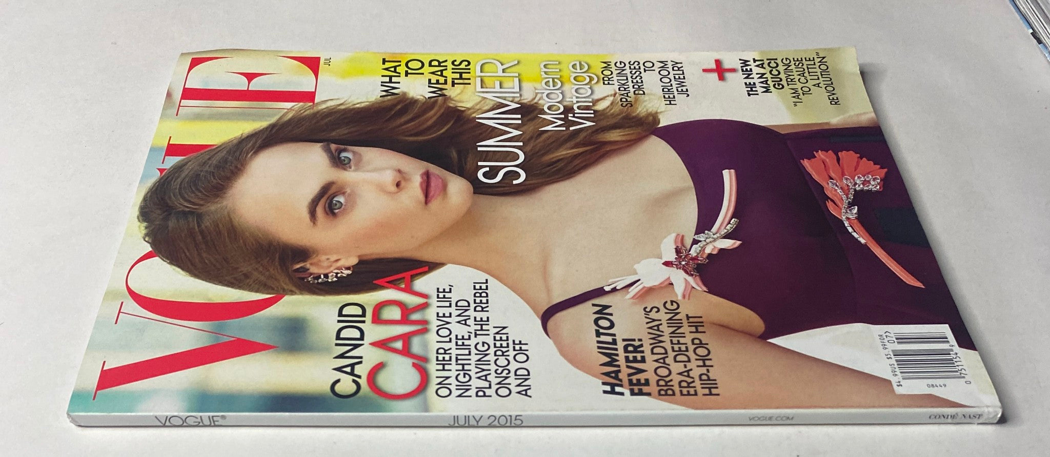 Vogue Magazine July 2015 Cover with Cara Delevingne, showcasing her beauty and fashion influence. The issue emphasizes summer trends and includes cultural commentary.
