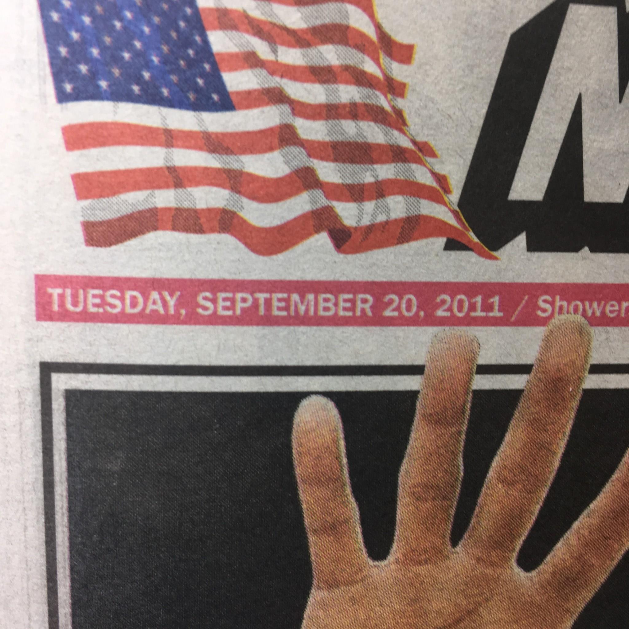 Close-up of the New York Post highlighting the date 'Tuesday, September 20, 2011' alongside an image of a hand gesture, part of the story 'IN A TIX FIX 17 scandal cops facing indict today'.