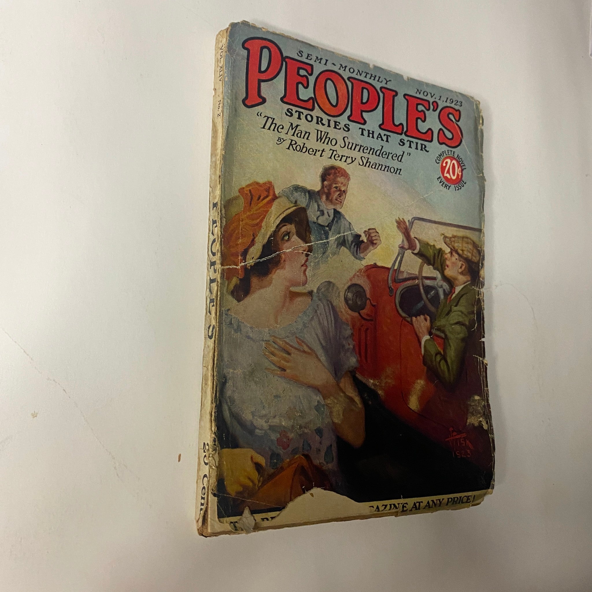 Close-up view of the 1923 PEOPLE'S Pulp Magazine cover showcasing 'The Man Who Surrendered' by Robert Terry Shannon. Highlights the vintage art style and condition details of the magazine.