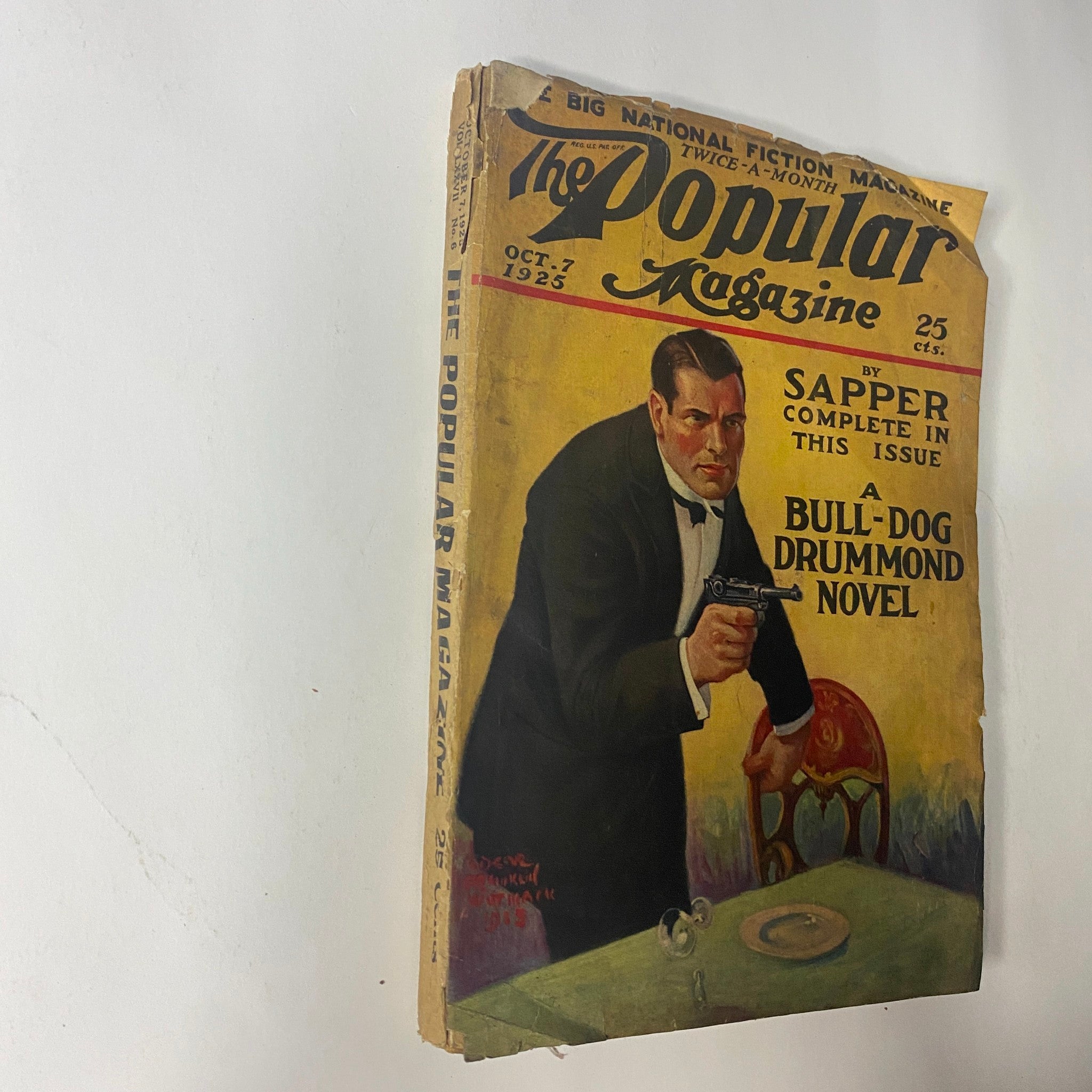 Side view of The Popular Magazine October 7, 1925, illustrating its cover titled 'The Nameless Terror' with a centerpiece image of a man with a gun, highlighting its vintage pulp fiction theme.