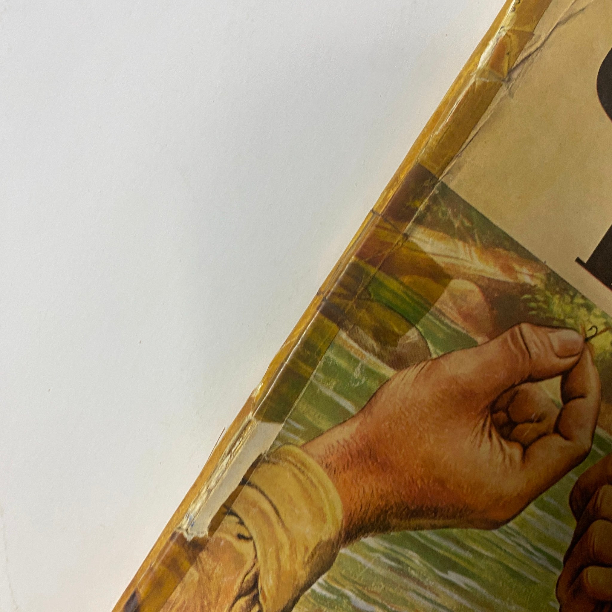Close-up view of the cover of Outdoor Life Magazine, July 1947 edition, highlighting detailed artwork of hands holding fishing hooks, emphasizing vintage outdoor activities.