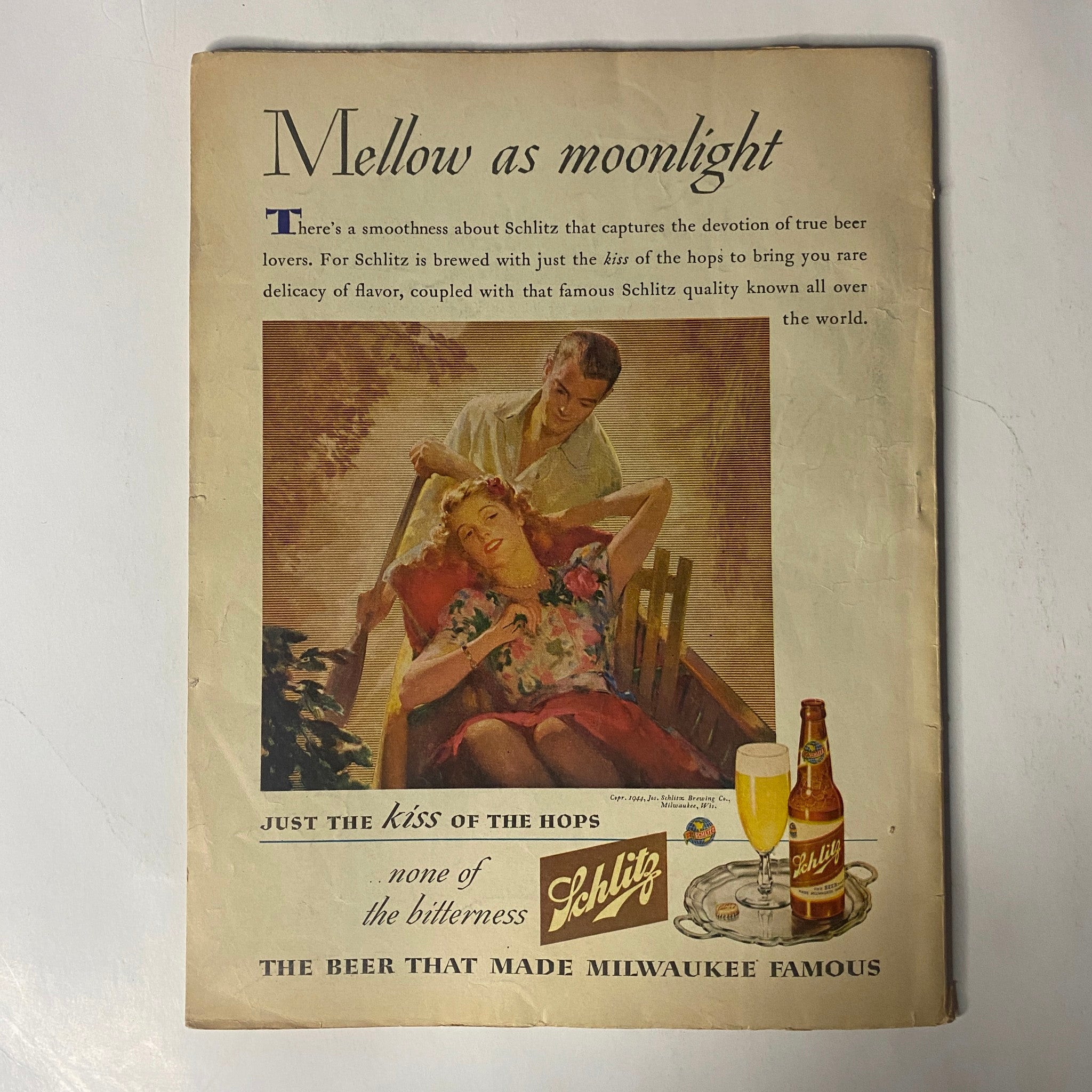 Back cover of Radio Mirror Magazine August 1944 showcasing an advertisement for Schlitz beer, featuring a romantic scene with a woman resting and a man pouring beer.