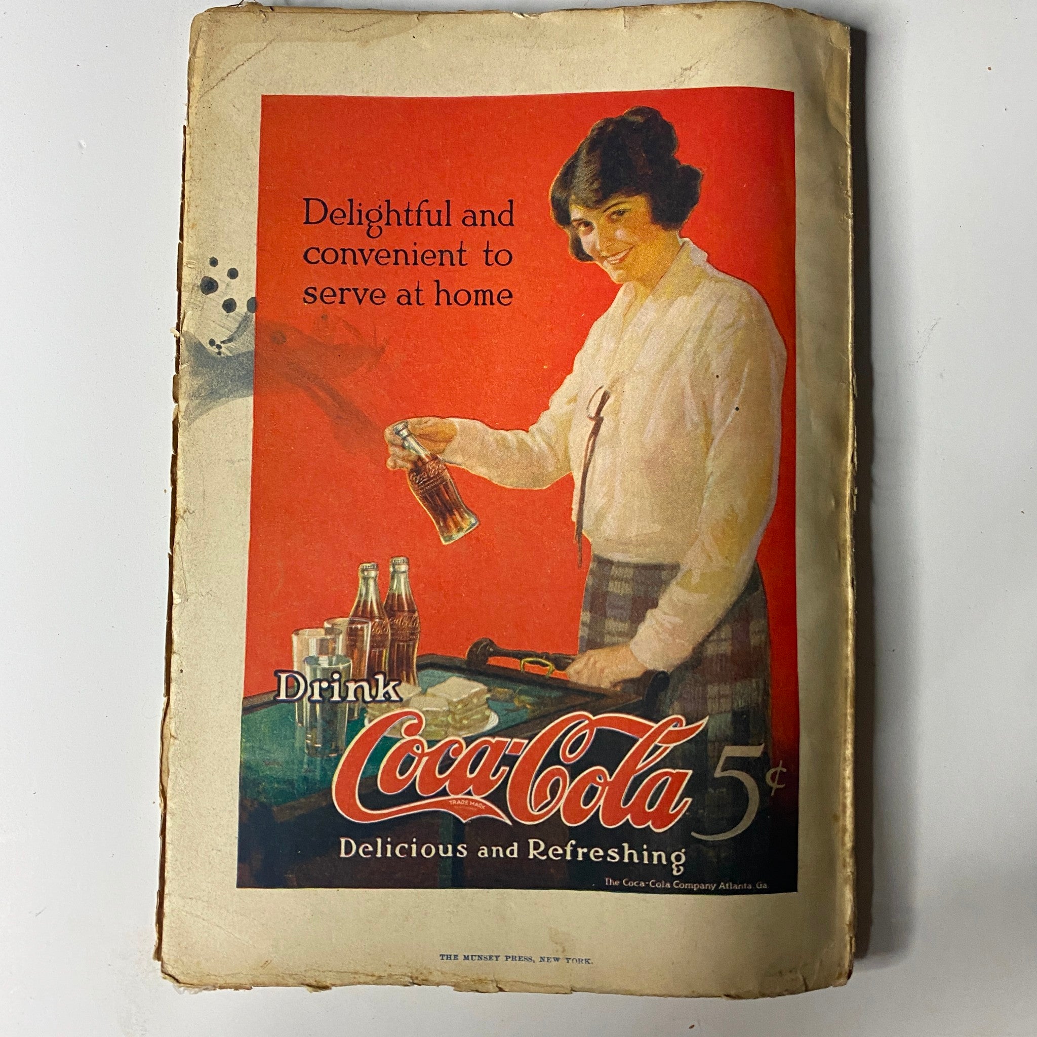 Vintage advertisement for Coca-Cola from the 1920s, titled 'Delightful and convenient to serve at home', showcasing a woman pouring a drink, located in the back of Argosy All-Story Weekly, October 27, 1923.