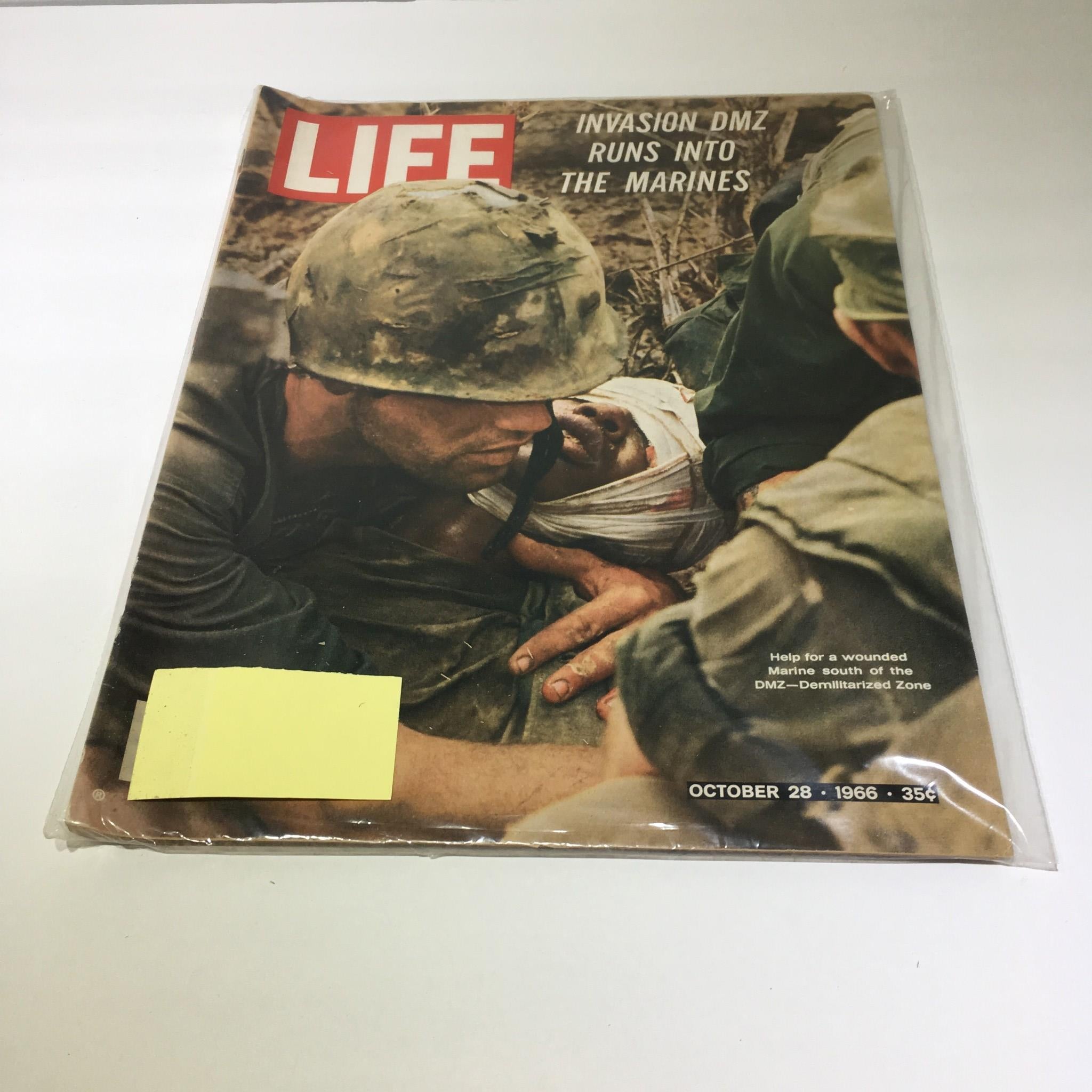 Vintage Life Magazine from October 28, 1966, featuring the cover story 'Help For A Wounded Marine South Of DMZ.' The image showcases a poignant moment of military personnel aiding a wounded marine, highlighted by the magazine's notable headline and the iconic Life logo.