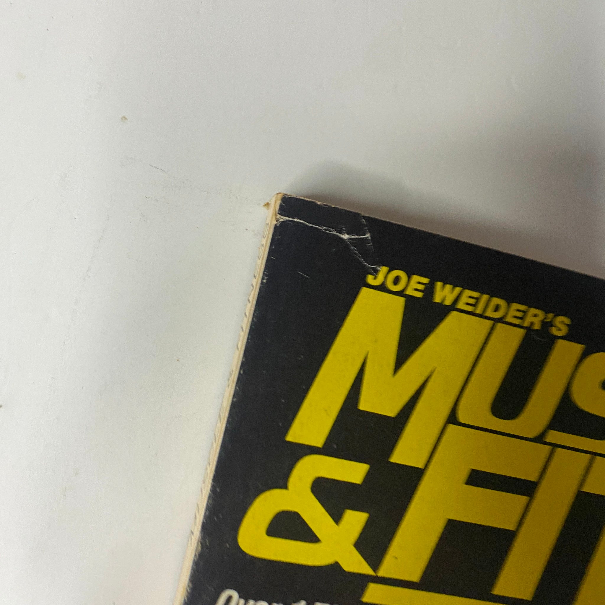 Close-up of the spine of Muscle & Fitness Magazine February 1984, noting Joe Weider's branding.