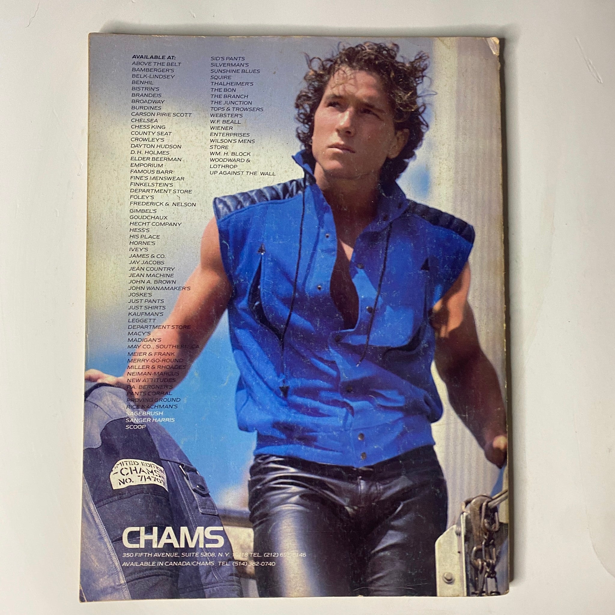Back cover of Muscle & Fitness Magazine November 1984 featuring a male model in a blue sleeveless shirt and leather pants. The text showcases advertisements and highlights from the magazine, emphasizing the mid-1980s bodybuilding scene.
