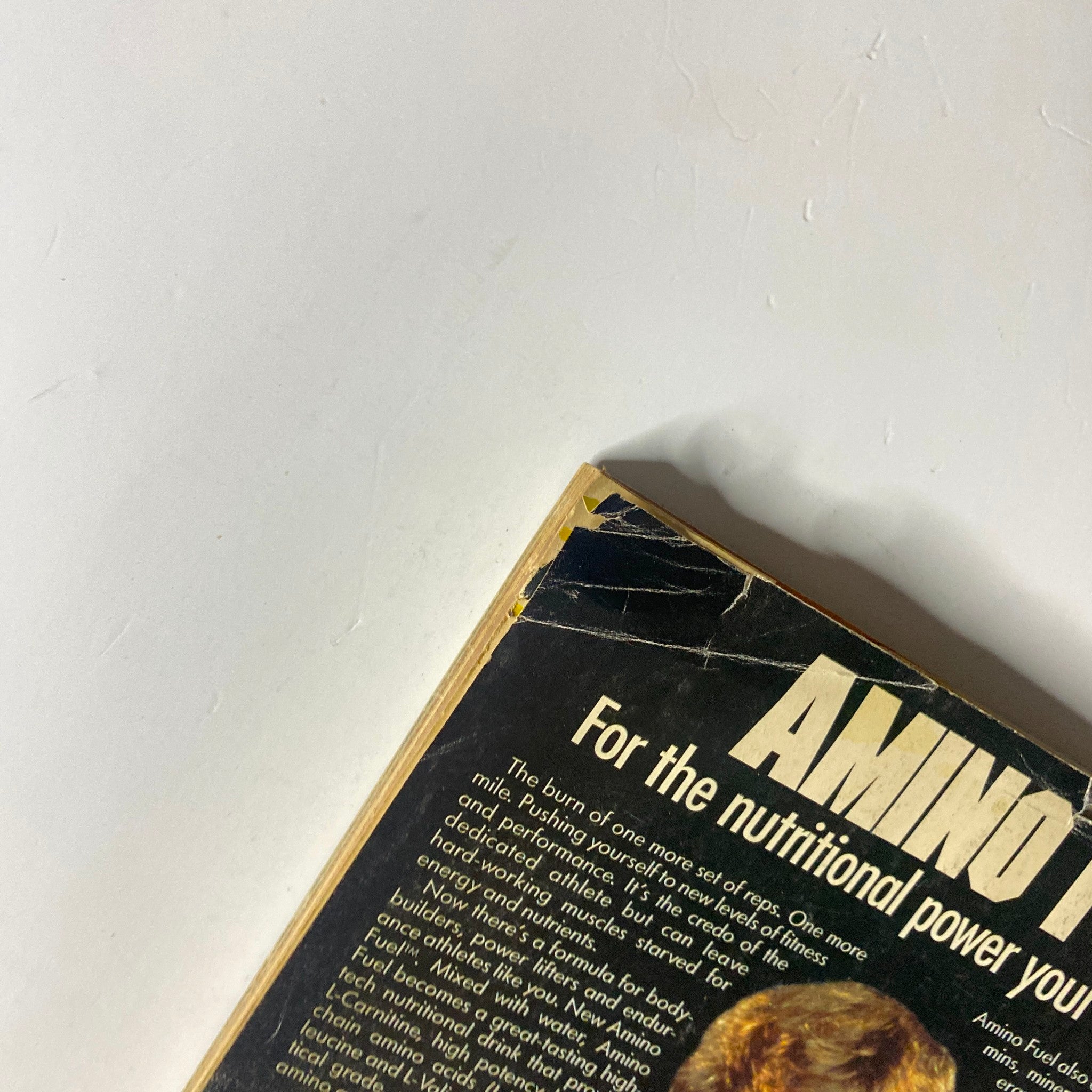 Close-up view of the back cover of Muscle & Fitness Magazine August 1987, highlighting details from the Amino Fuel advertisement, showcasing the product's benefits for athletes.