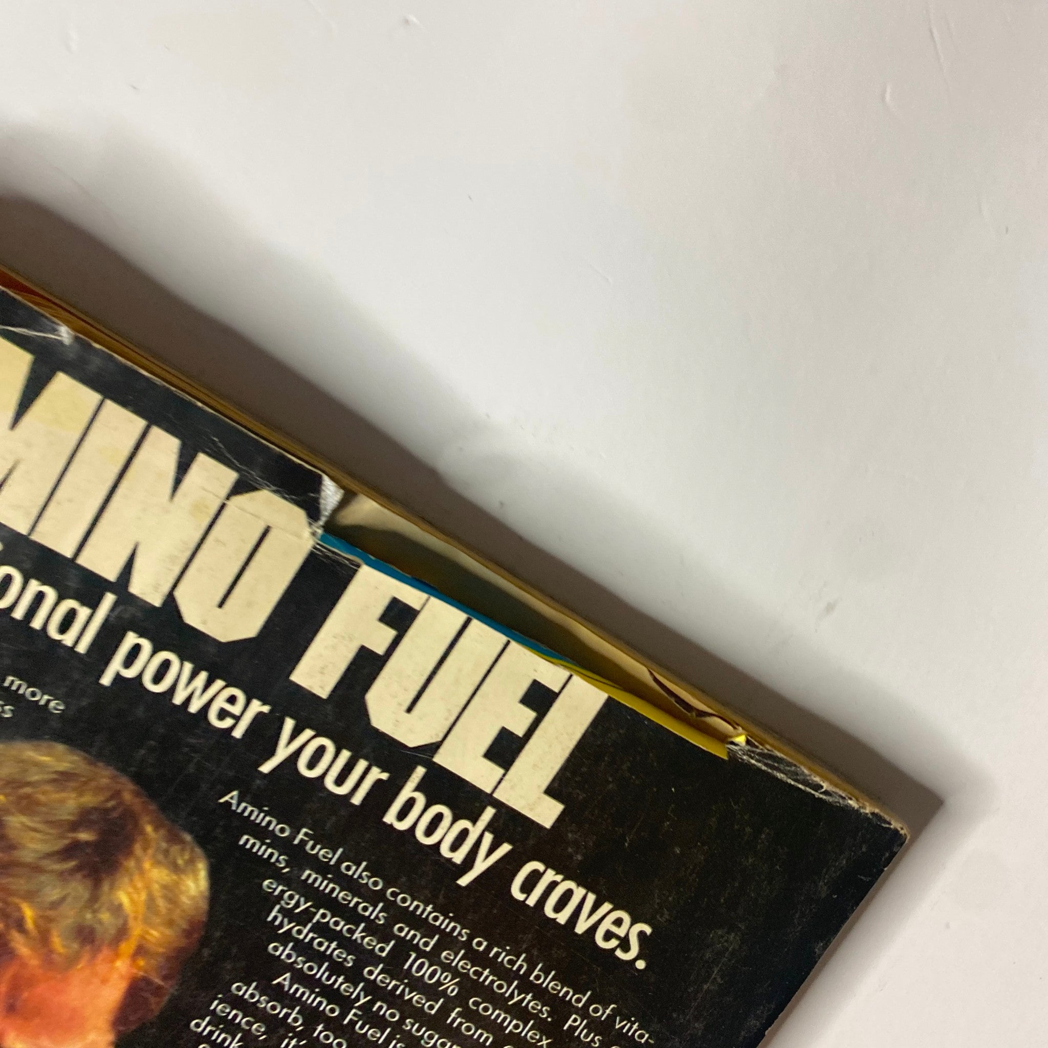 Detailed corner view of Amino Fuel advertisement on the back cover of Muscle & Fitness Magazine August 1987, illustrating its focus on bodybuilding nutrition.
