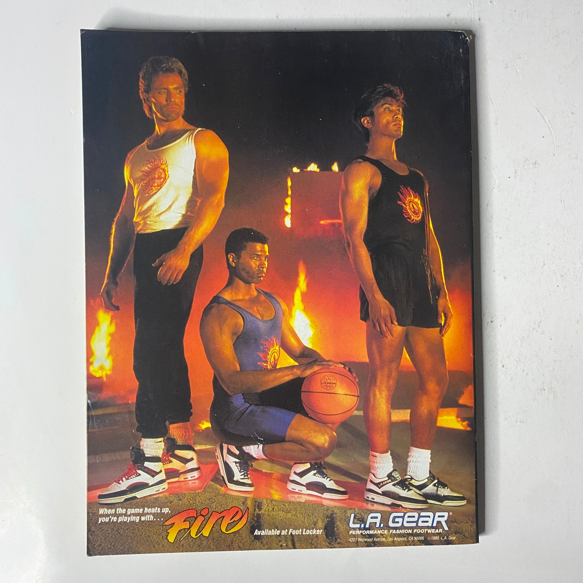 L.A. Gear advertisement featuring three male models in sportswear, highlighting the brand 'Fire' for athletic footwear, emphasizing the connection to basketball and fitness.