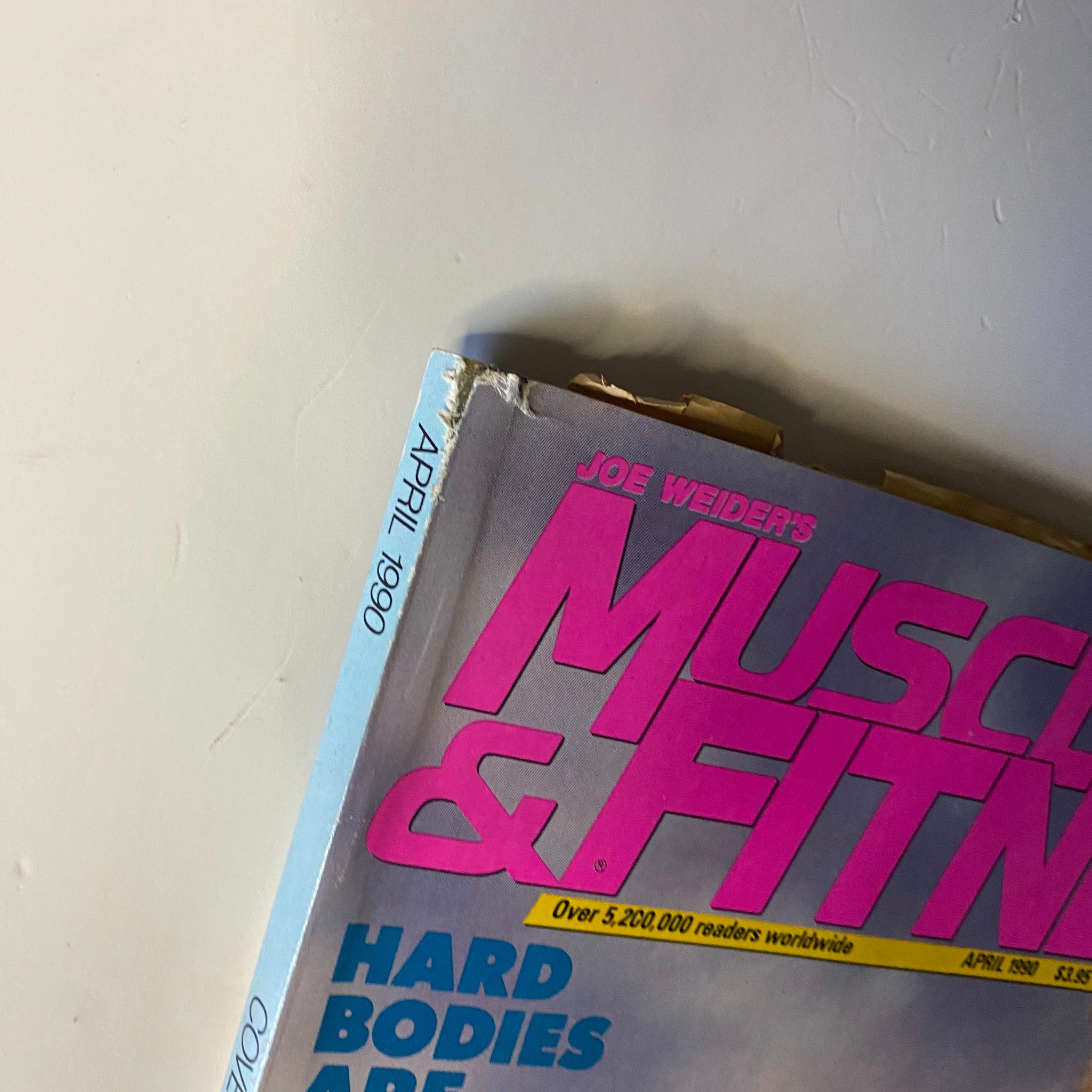 Top view of Muscle & Fitness Magazine April 1990 featuring a corner showing issue details with the title and year prominently displayed.