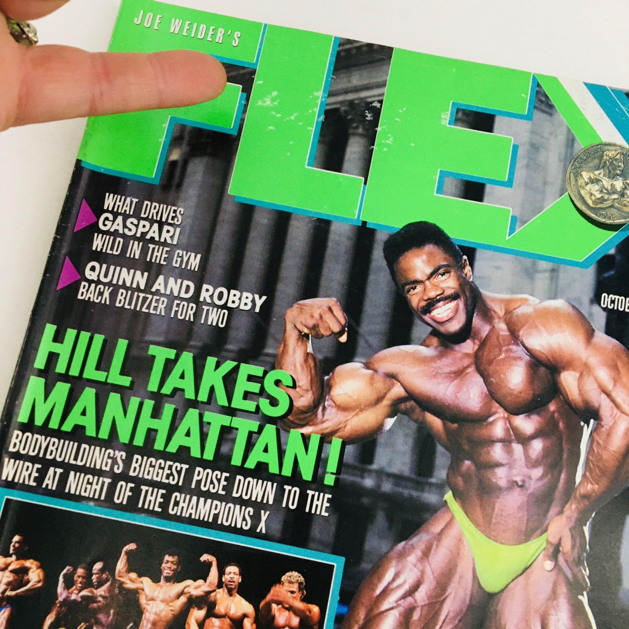 Close-up of the cover of Joe Weider's Flex Magazine, October 1988, with an emphasis on bodybuilder Phil Hill and the dynamic headline 'HILL TAKES MANHATTAN!'.