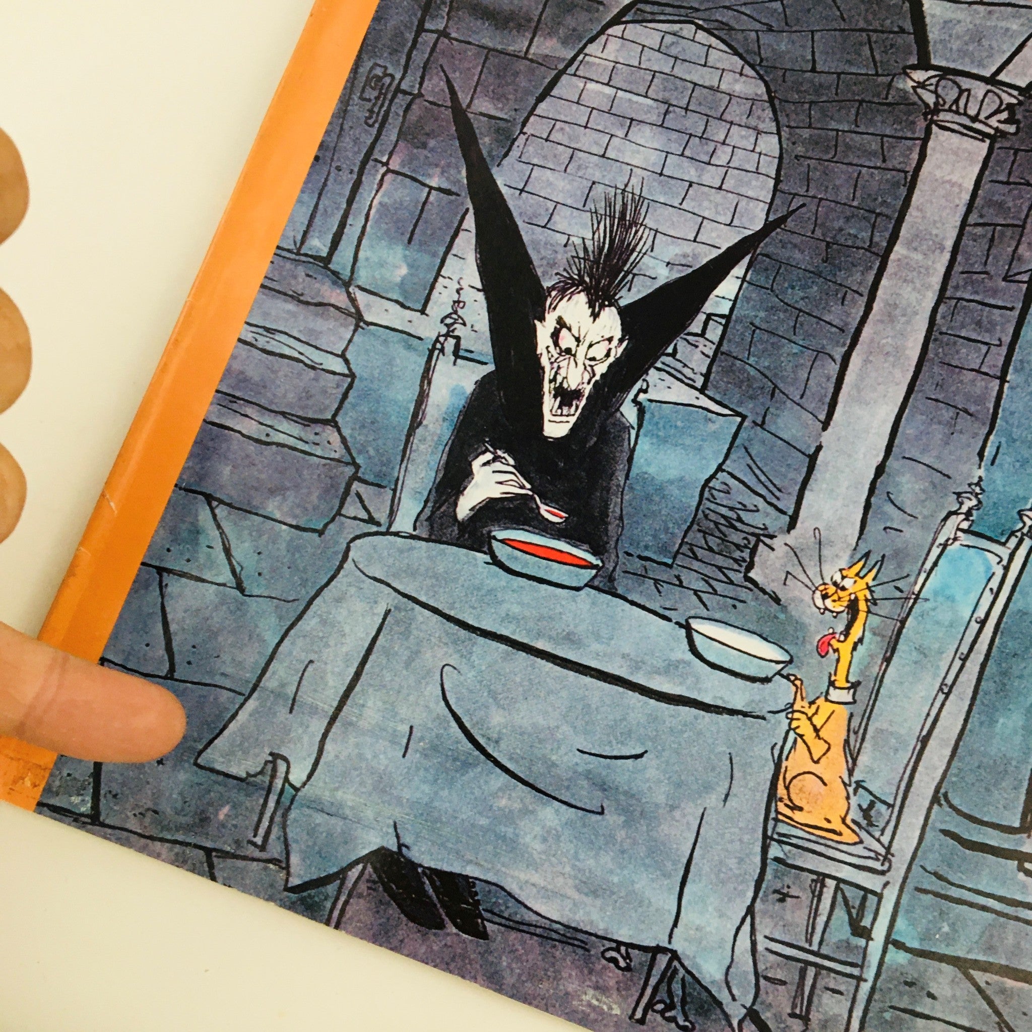 Close-up view of The New Yorker Magazine October 31 2011 Full Theme Cover by George Booth showcasing a dark, playful character at a table with a cat, displaying the unique artistic elements of the cover.
