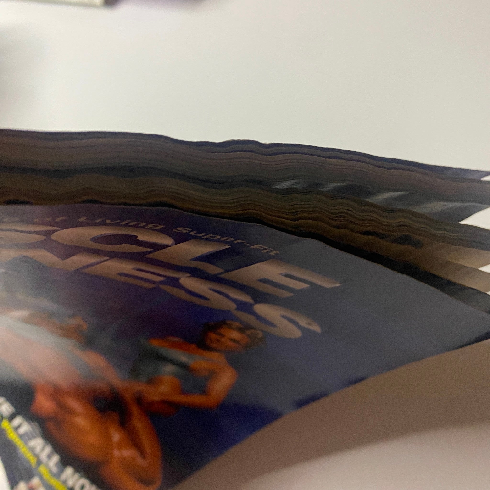 Close-up view of the spine of Muscle & Fitness Magazine July 1996, featuring a worn cover, highlighting the issue's theme on the 1996 Arnold Classic Weekend.