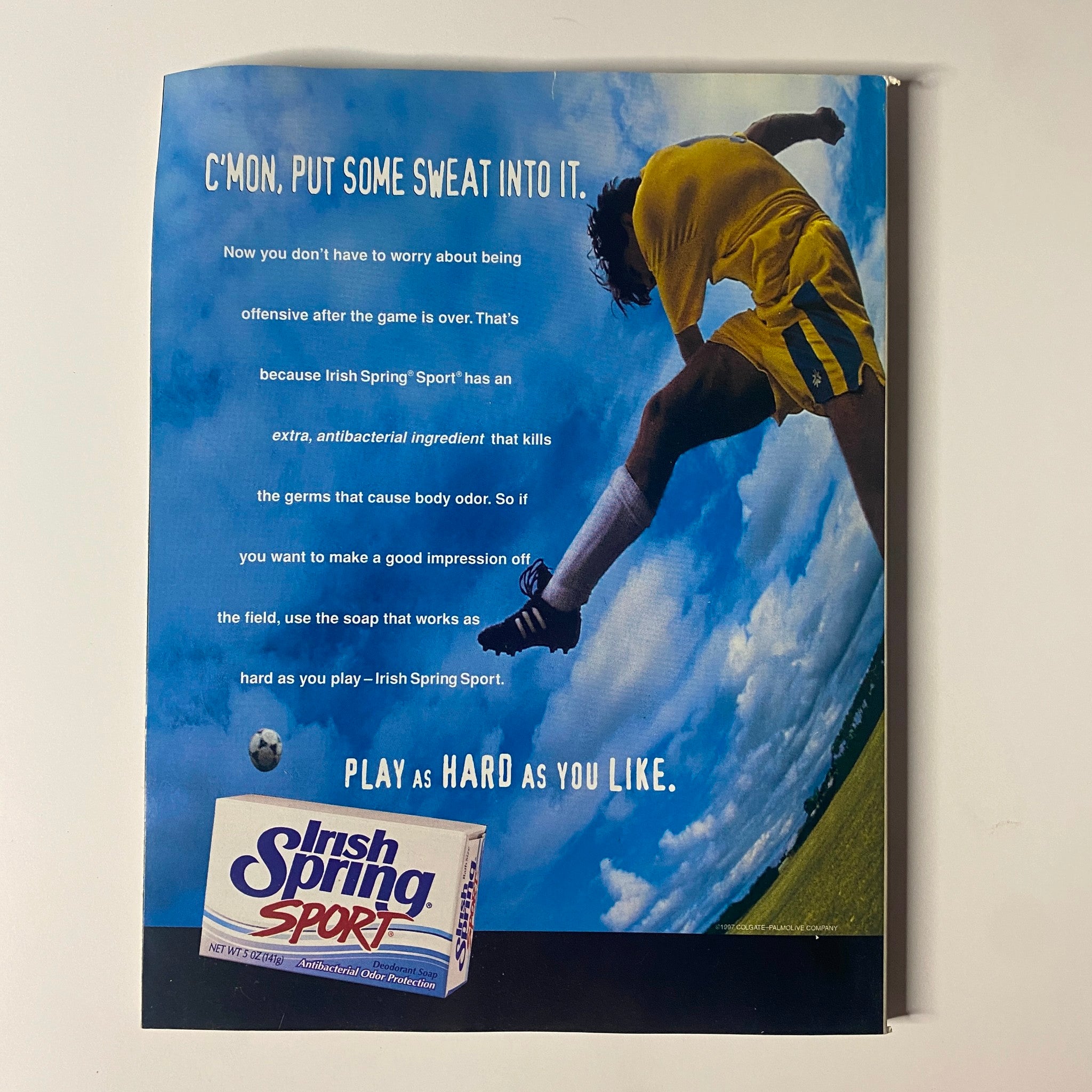 C'mon, put some sweat into it! Advertising poster for Irish Spring Sport soap, featuring a soccer player in action, emphasizing freshness and cleanliness for athletes after sporting activities. Muscle & Fitness Magazine – March 1998 – Vol. 59, No. 3 – Roland Kickinger (No Label, VG).