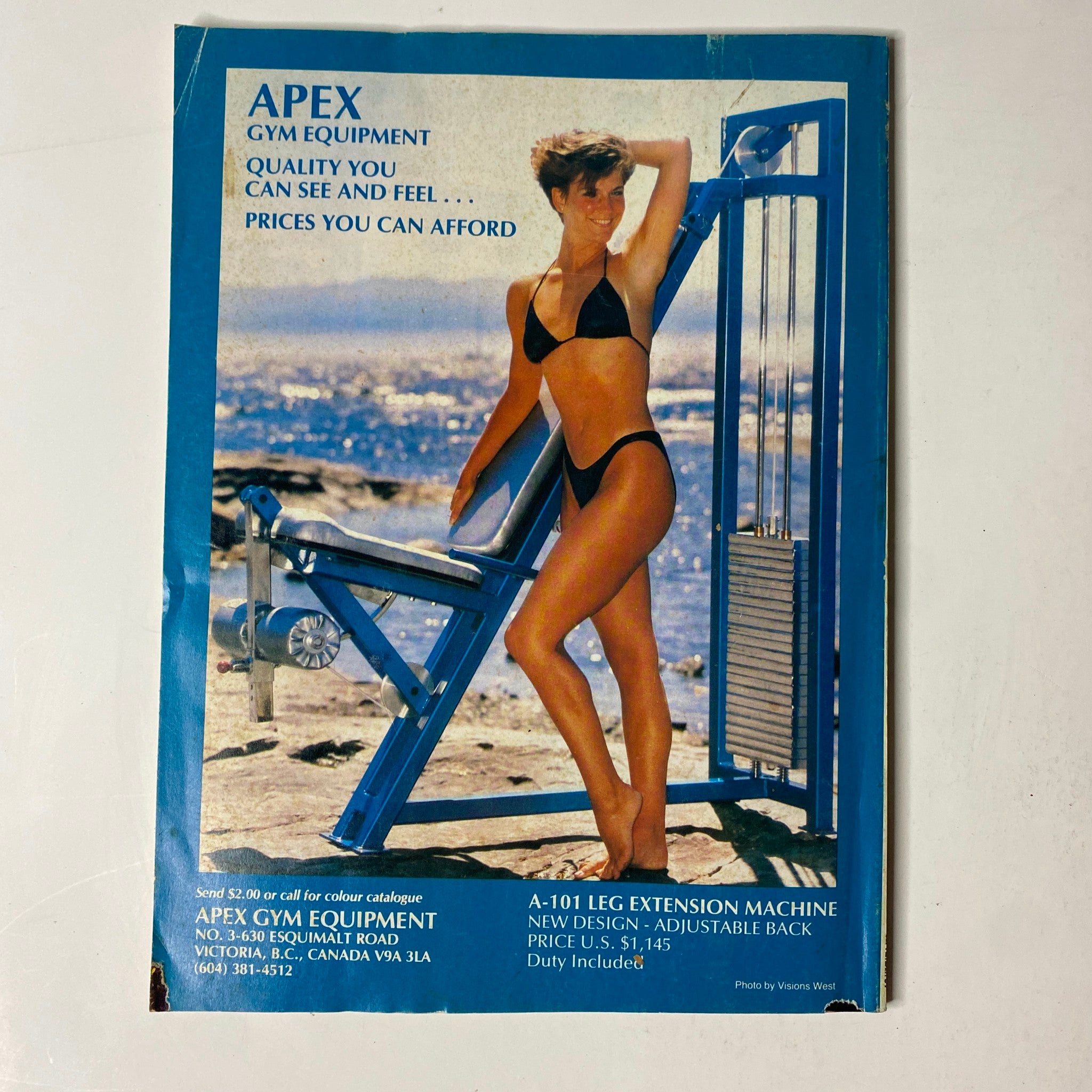 Advertisement for APEX gym equipment in MuscleMag International Magazine September 1989, showcasing an adjustable leg extension machine.