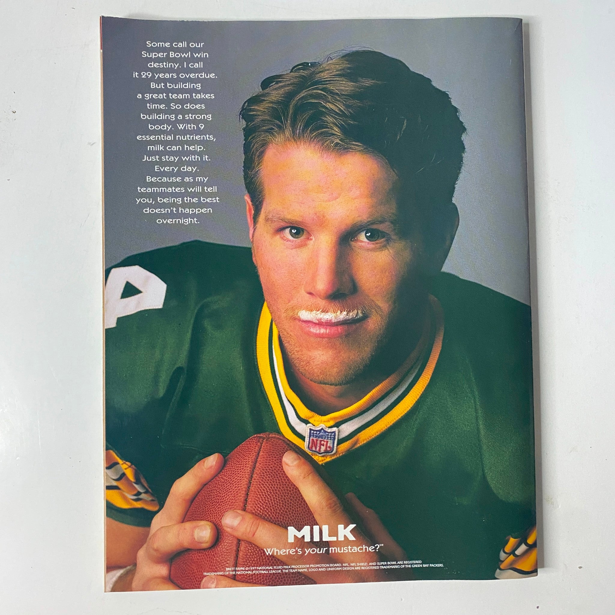 Advertisement featuring a football player in a green jersey with a milk mustache, promoting strength building, from Muscle & Fitness Magazine October 1997 Vol 58 No. 10.
