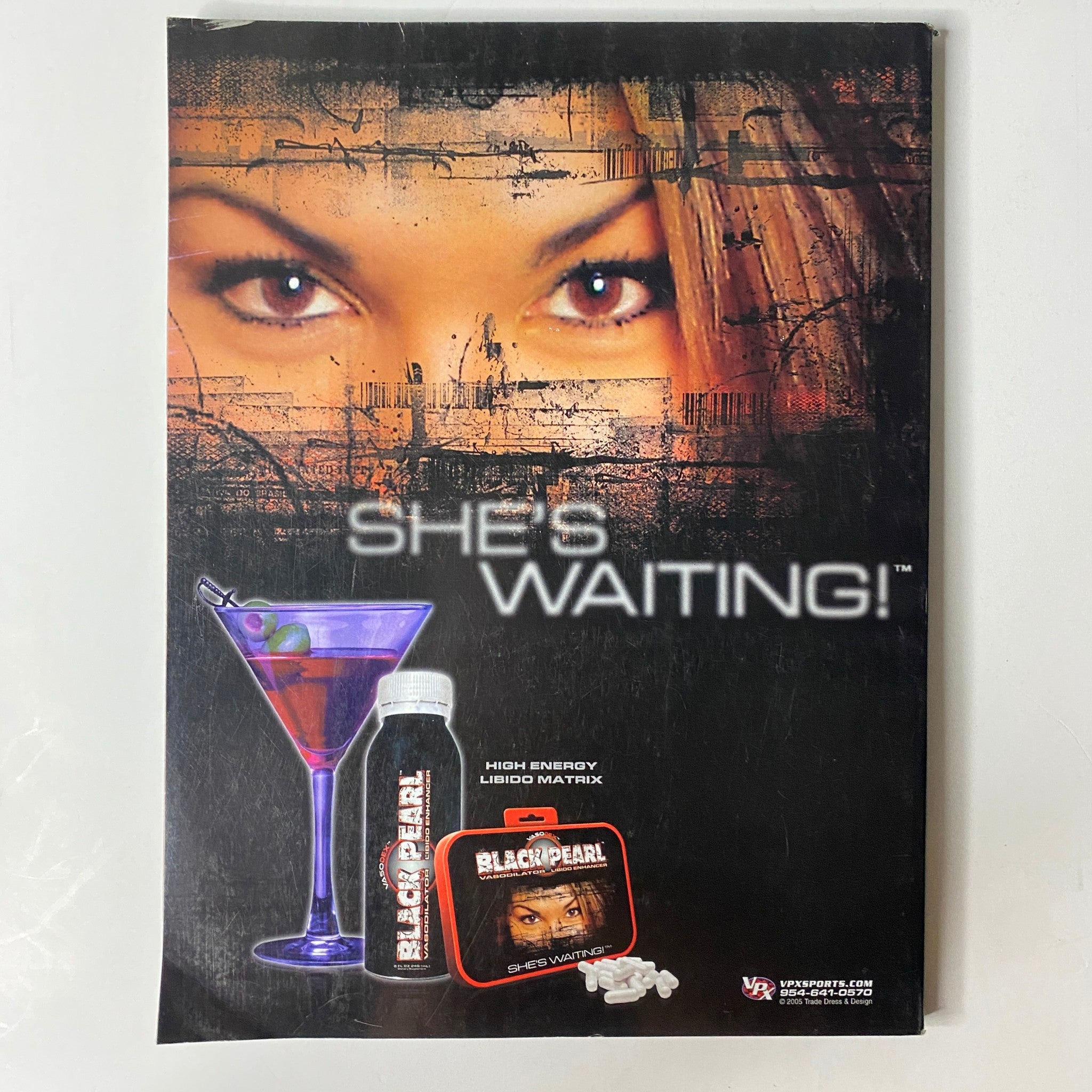 Muscle & Fitness Magazine July 2005 Vol 66 No. 7 advertisement with striking graphic of a woman and text 'SHE'S WAITING!', promoting high-energy drink in a stylish layout.