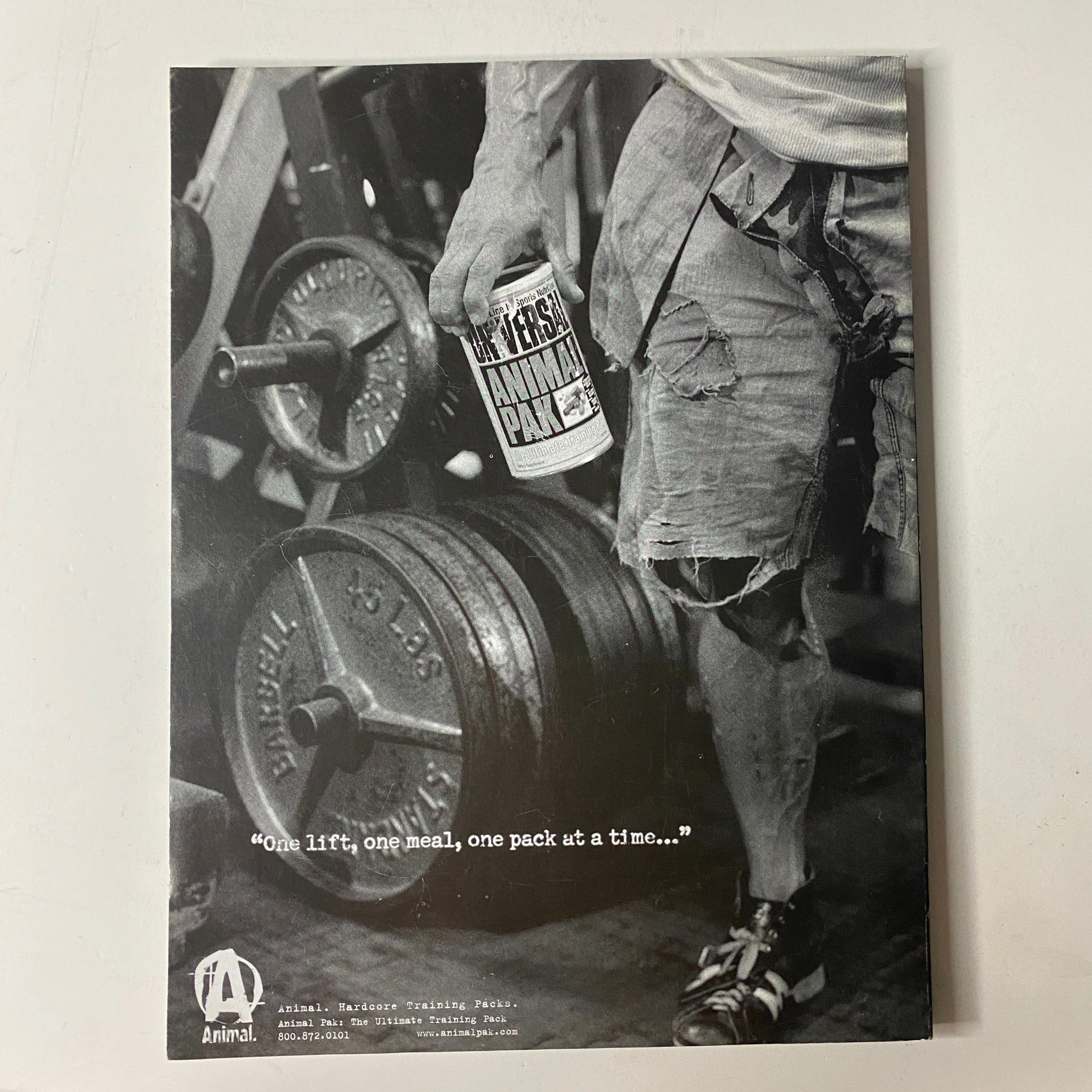 Back cover of Muscle & Fitness Magazine October 2006 featuring a weightlifting advertisement with the caption 'One lift, one meal, one pack at a time...'.