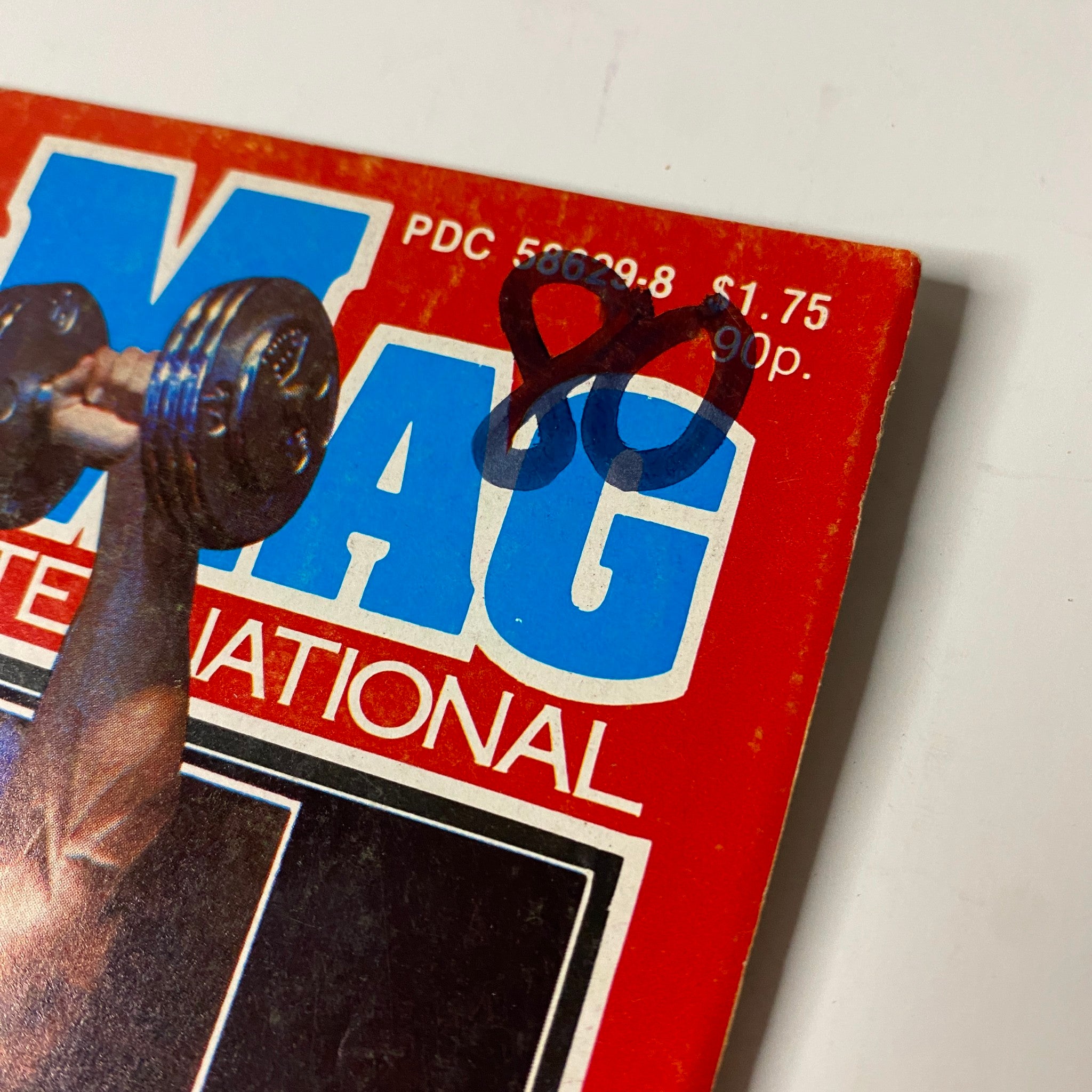 Close-up of a vintage MuscleMag International Magazine May 1980 with a notable mark on the cover, emphasizing the magazine's collectible nature.