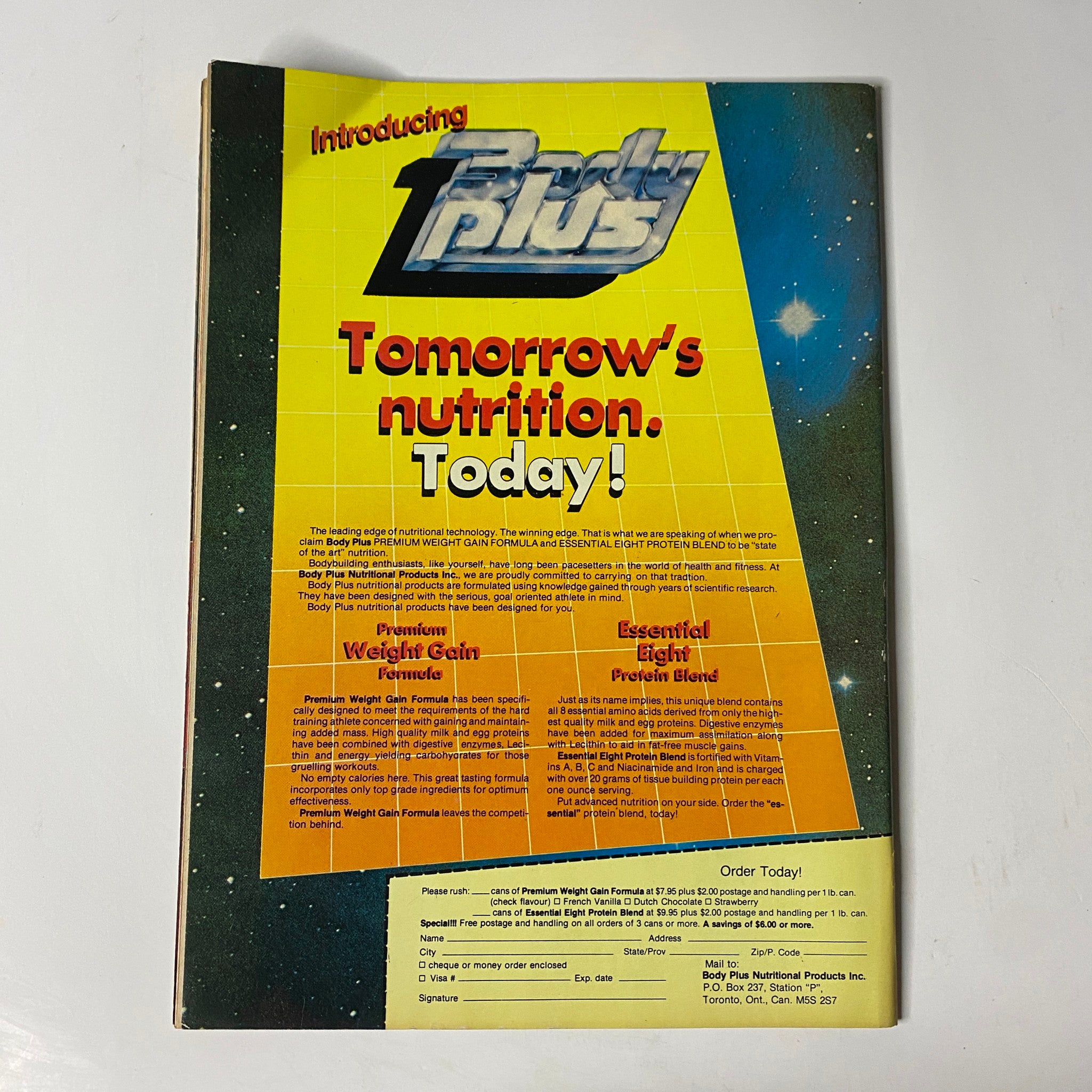 Back cover of MuscleMag International Magazine October 1985 featuring an advertisement for Body Plus, promoting nutritional products for bodybuilding, emphasizing 'Tomorrow's nutrition. Today!' with a vibrant, colorful design.