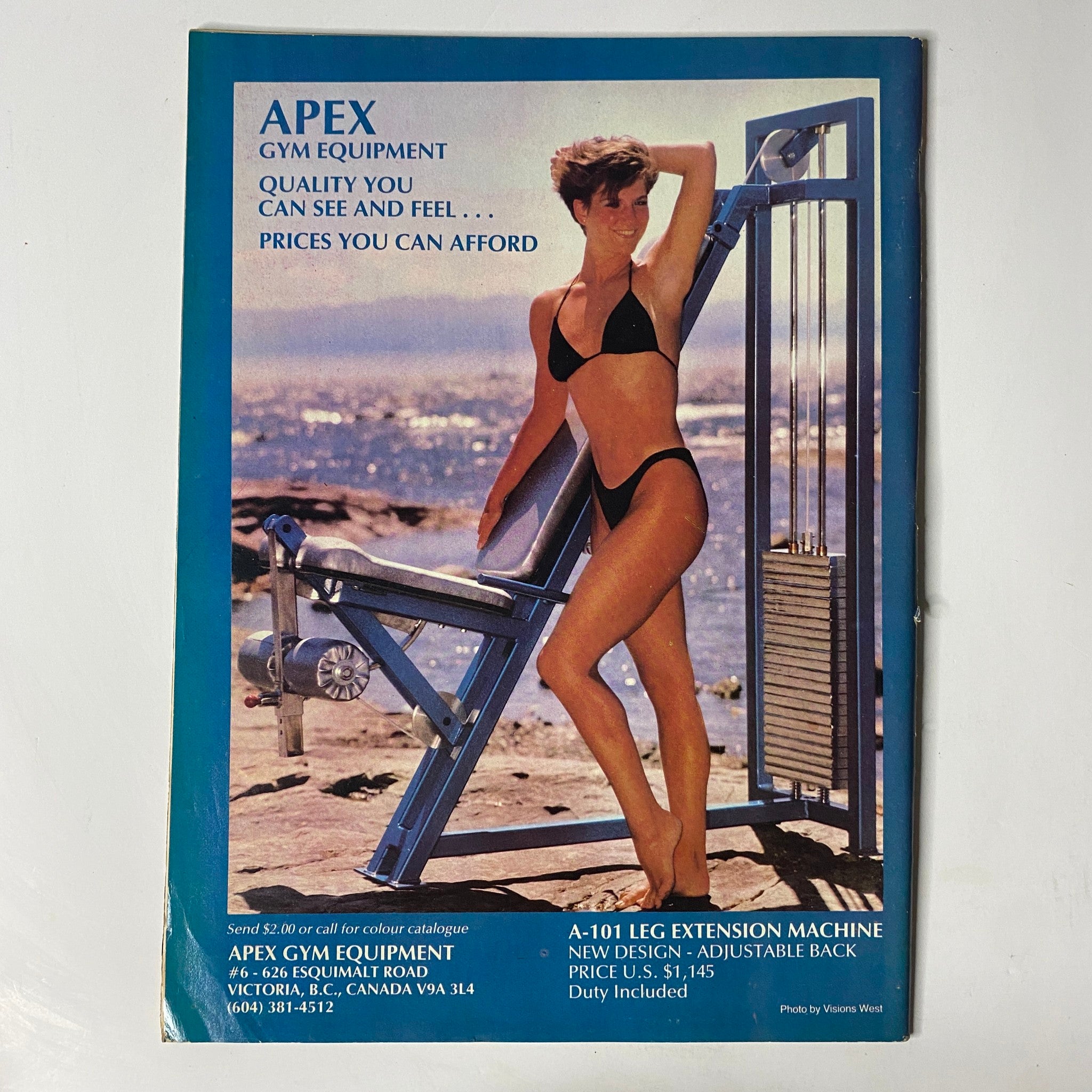 Advertisement for Apex Gym Equipment featured in MuscleMag International Magazine April 1986 Vol 11 No. 2, promoting quality fitness equipment and prices.