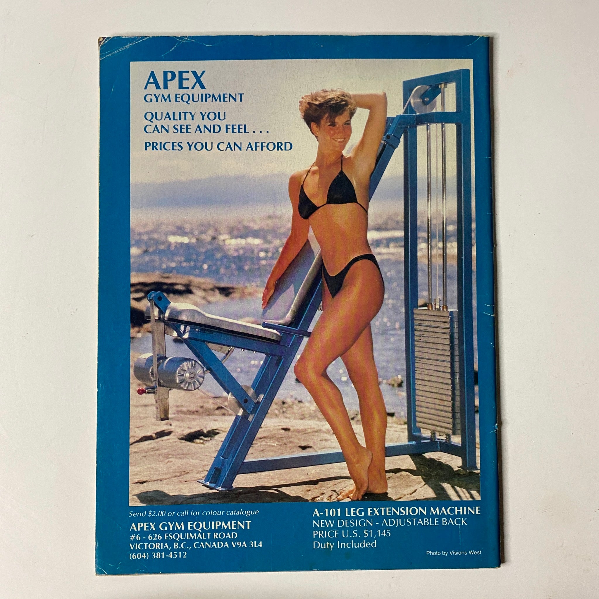 Back cover advertisement of MuscleMag International Magazine February 1988 No. 71 promoting APEX Gym Equipment with a model in a bikini.