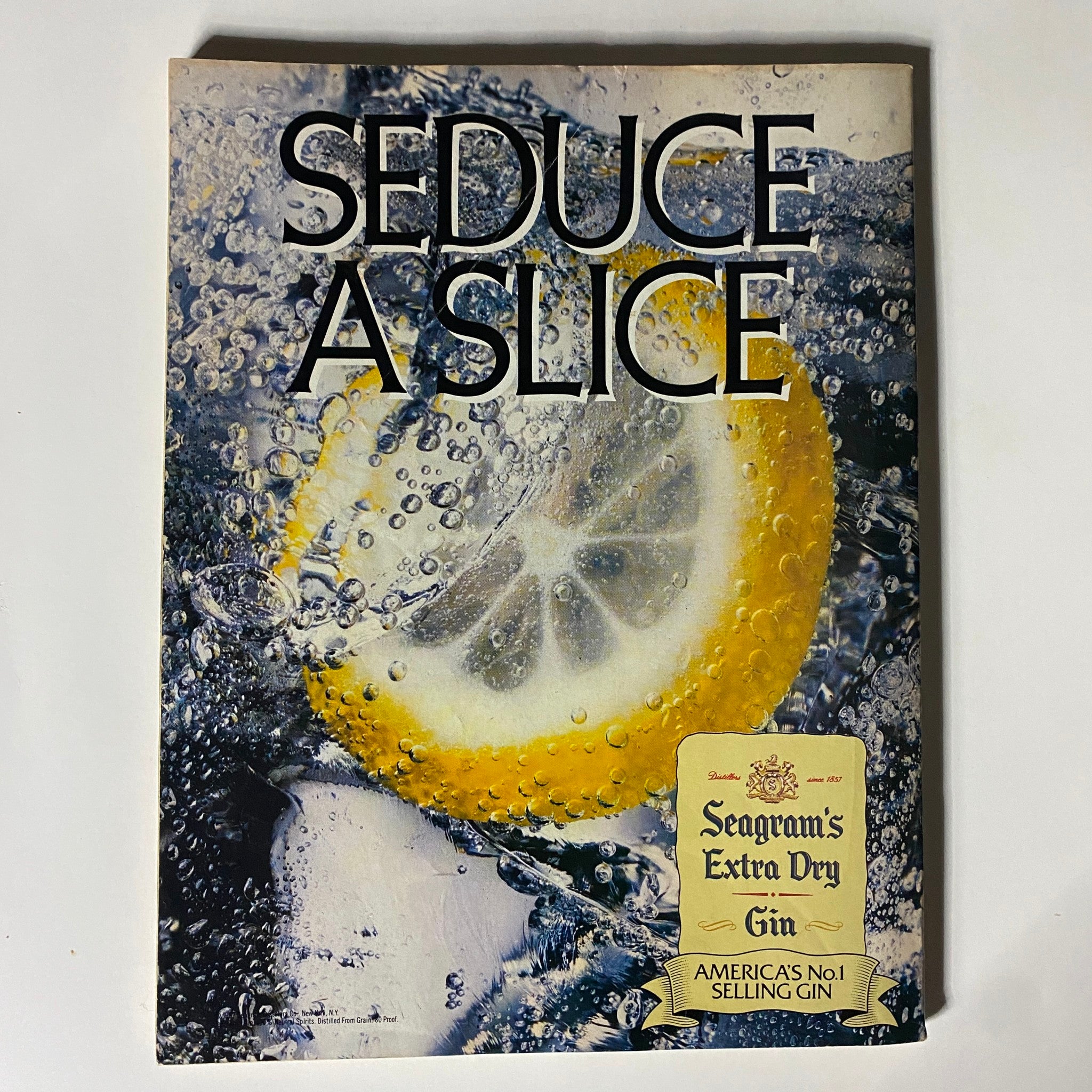 Vintage advertisement page from VTG Street & Smith's Olympics Magazine 1988 promoting Seagram's Extra Dry Gin. The image captures a refreshing lemon slice submerged in bubbles, emphasizing a beverage-related feature within the magazine.