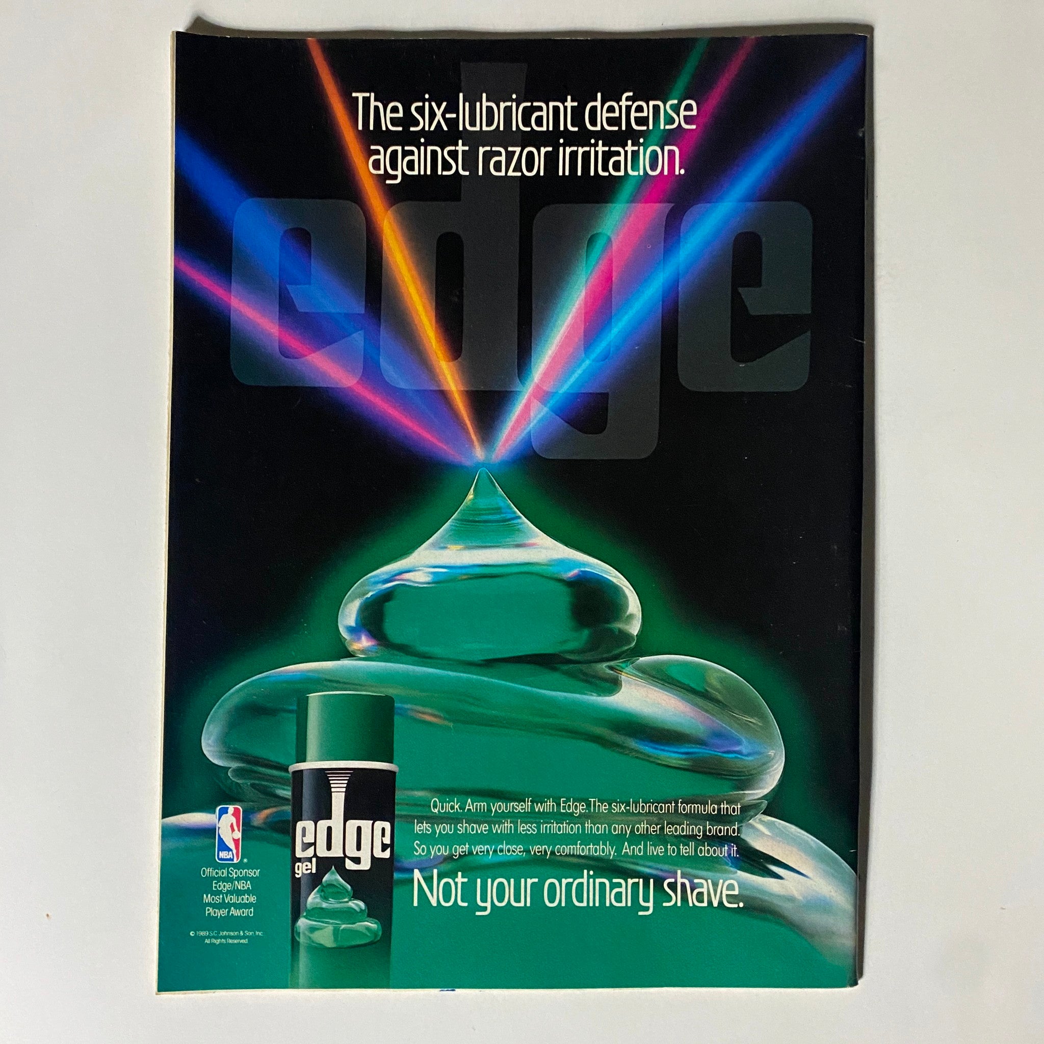 Advertisement for Edge shaving gel from Basketball Digest Magazine, promoting its six-lubricant formula with the slogan 'Not your ordinary shave' in a visually striking design, highlighting its association with the NBA.