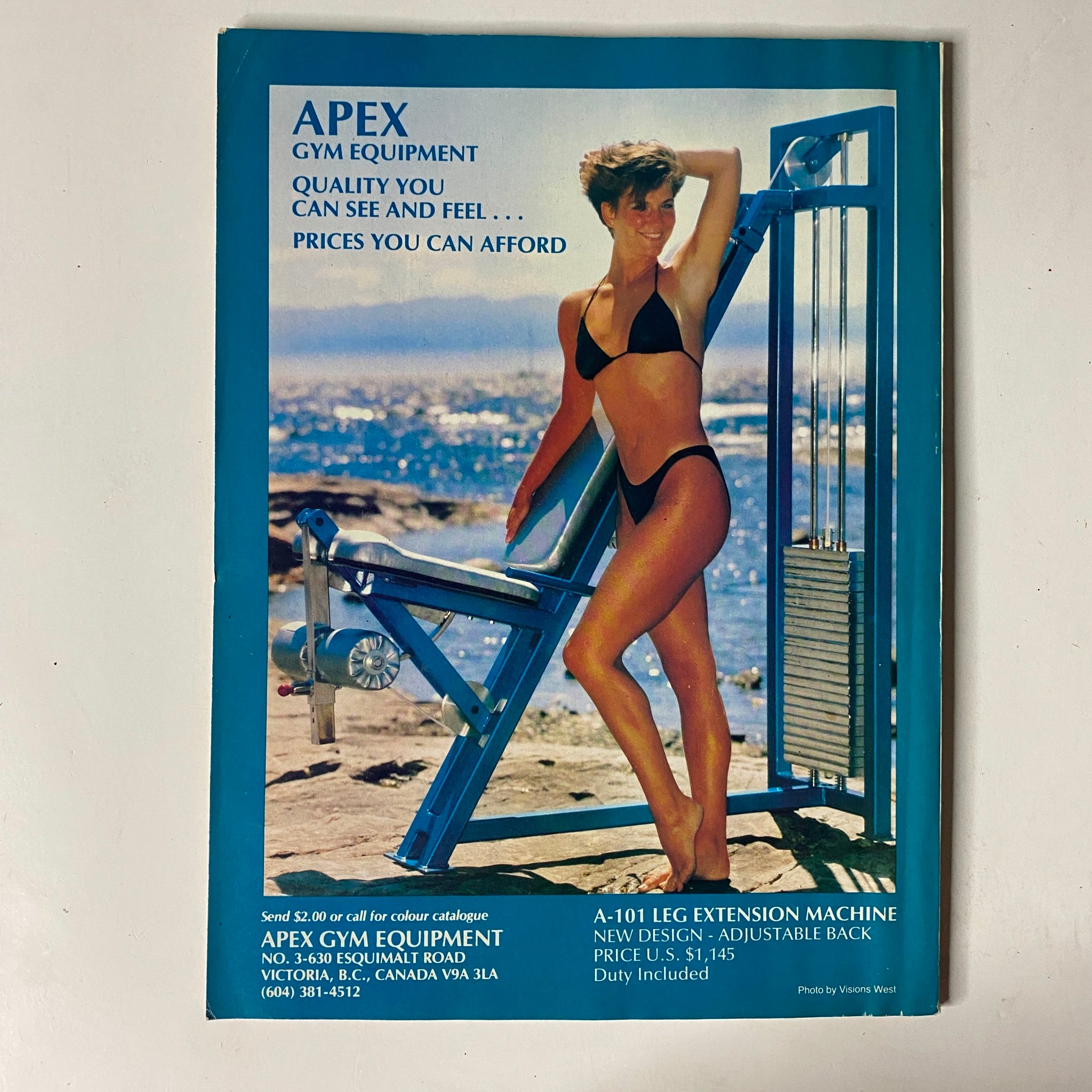 Back cover of MuscleMag International Magazine, November 1989, advertising Apex Gym Equipment. The cover features a model in a bikini showcasing gym equipment with scenic background.
