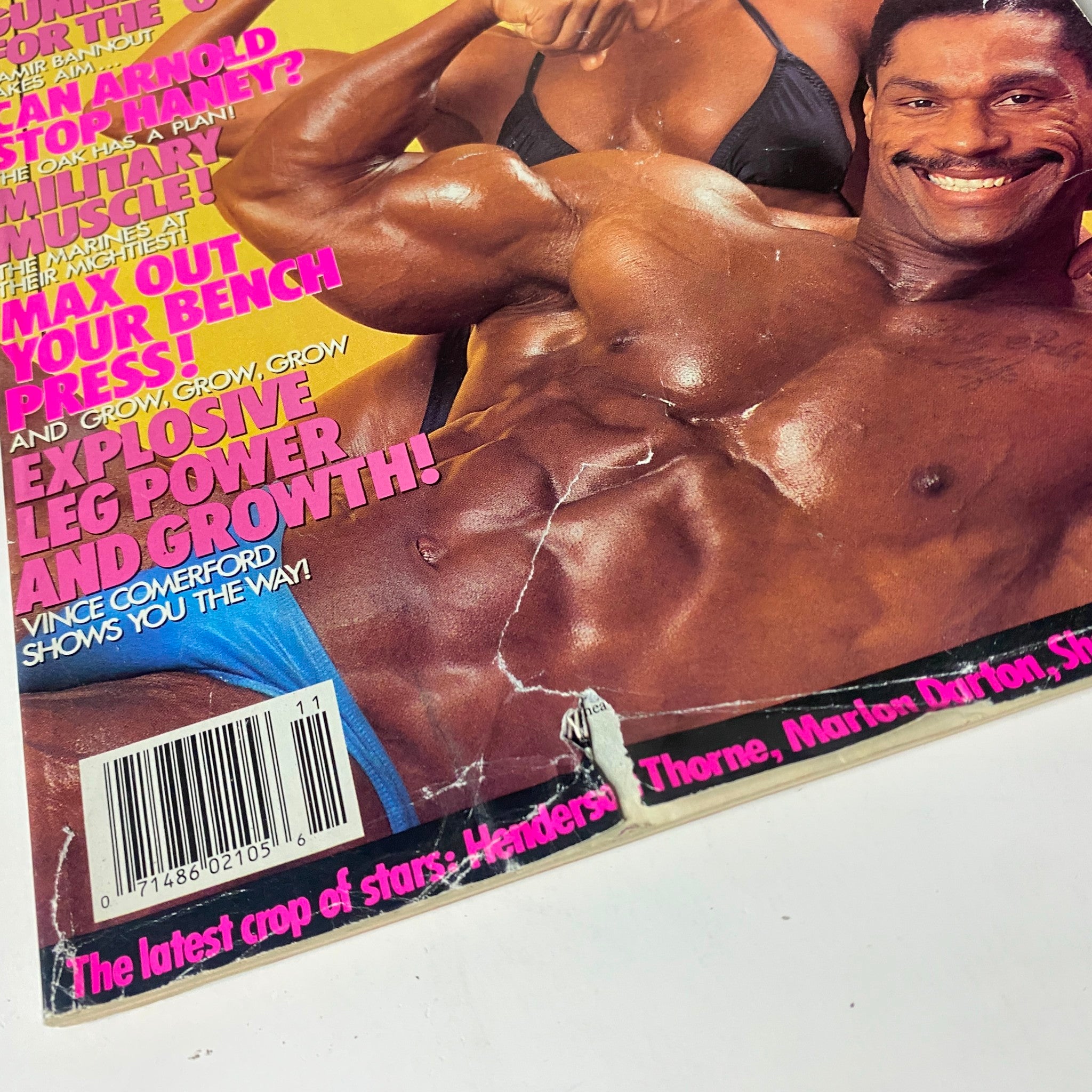 Close-up of the damaged cover of MuscleMag International Magazine November 1990, displaying wear and tear on the front featuring Mike Christian.