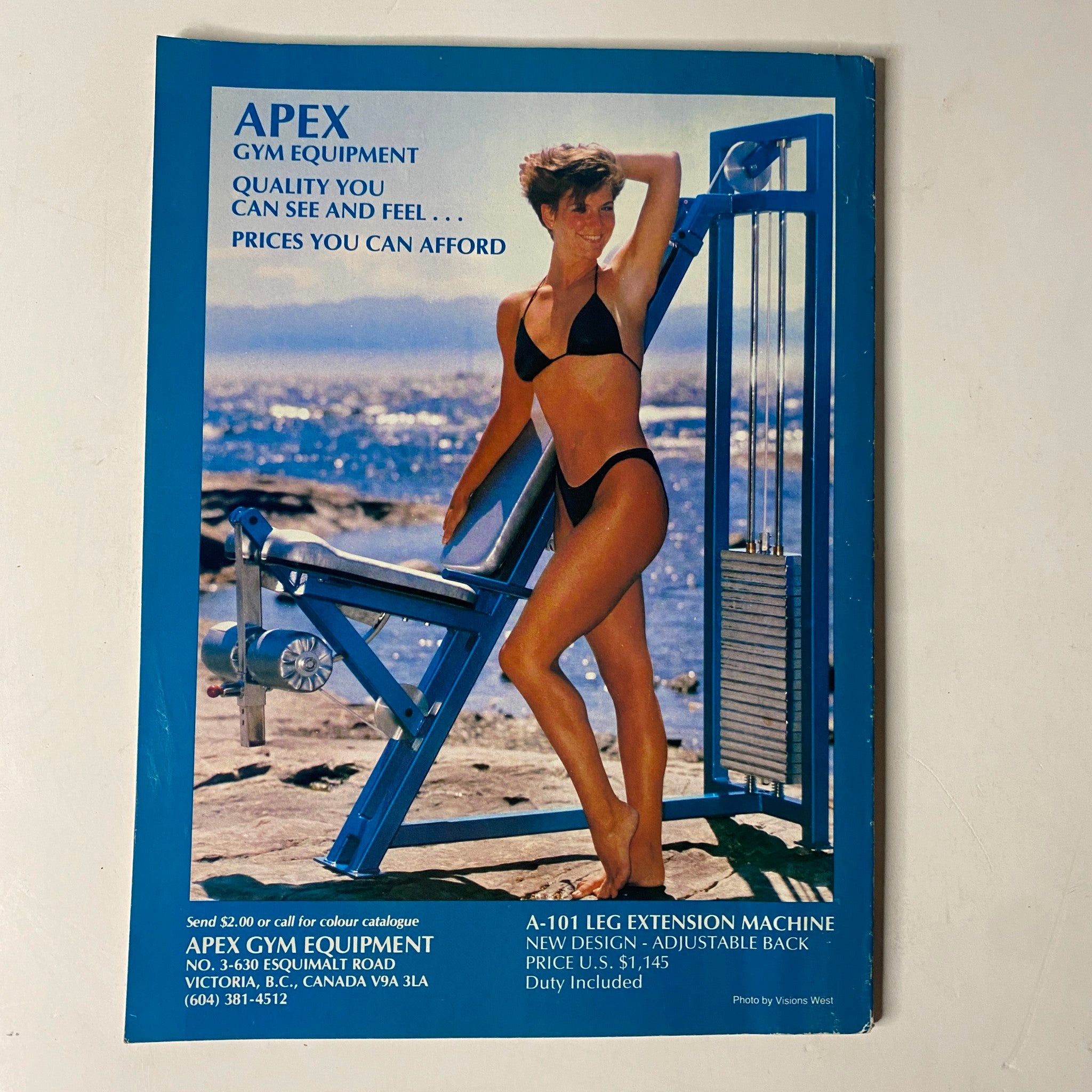 Back cover of MuscleMag International Magazine February 1990 advertising Apex Gym Equipment with a model posing, emphasizing quality fitness products.