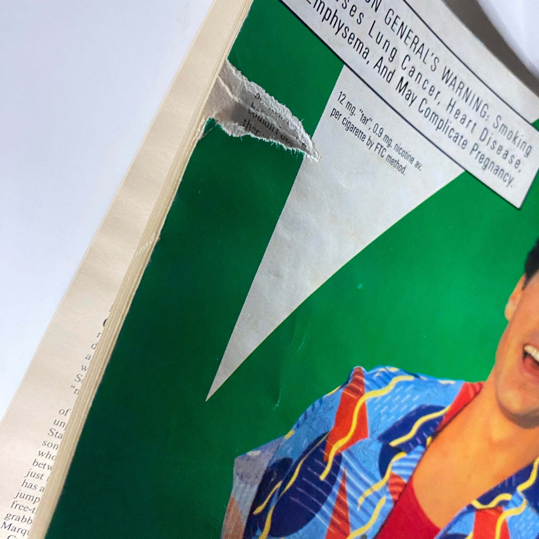 Close-up of a torn edge on an advertisement page from Dick Vitale's Basketball Magazine 1988-1989 illustrating vintage magazine wear.