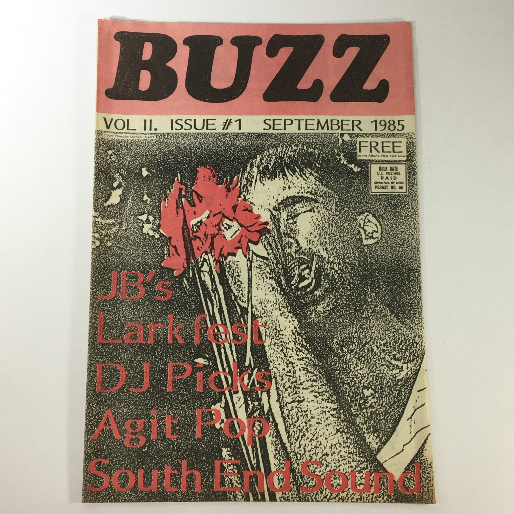 VTG Buzz Magazine September 1985 featuring JB's Lark Fest, DJ Picks, and Agit Pop Sound. The cover includes bold text on a vintage design with an artistic depiction of a musician.
