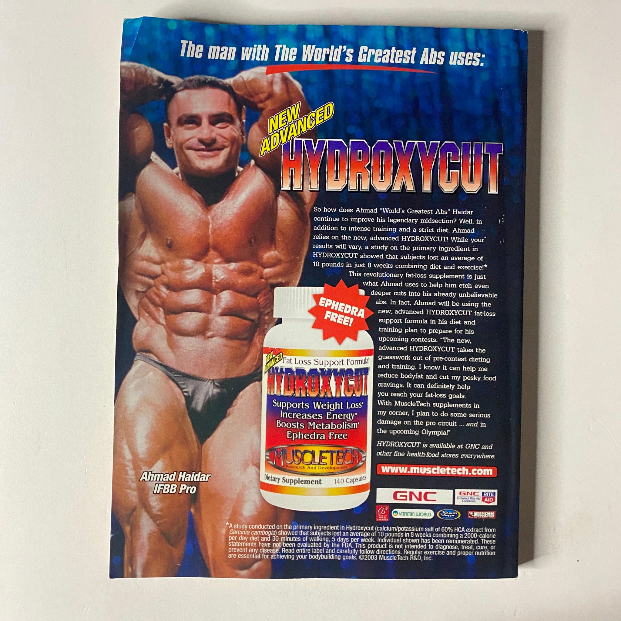 MuscleMag International Magazine August 2003, Issue No. 254 back cover advertisement for Hydroxycut featuring bodybuilder Ahmad Haidar, emphasizing weight loss support and fitness.
