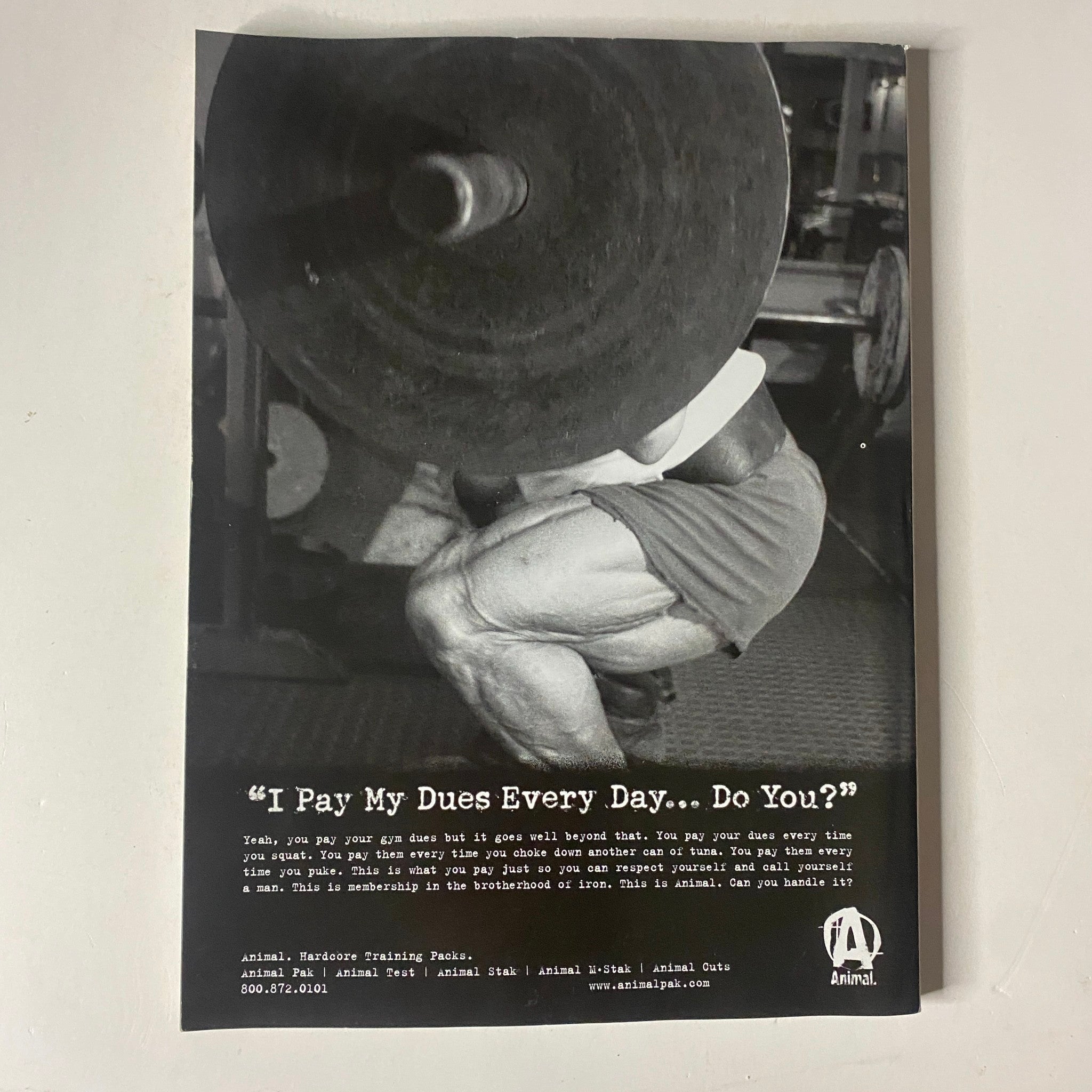 MuscleMag International Magazine October 2004, featuring a powerful black and white advertisement with the text 'I Pay My Dues Every Day... Do You?' showcasing a bodybuilder performing a squat with heavy weights, emphasizing dedication in training.