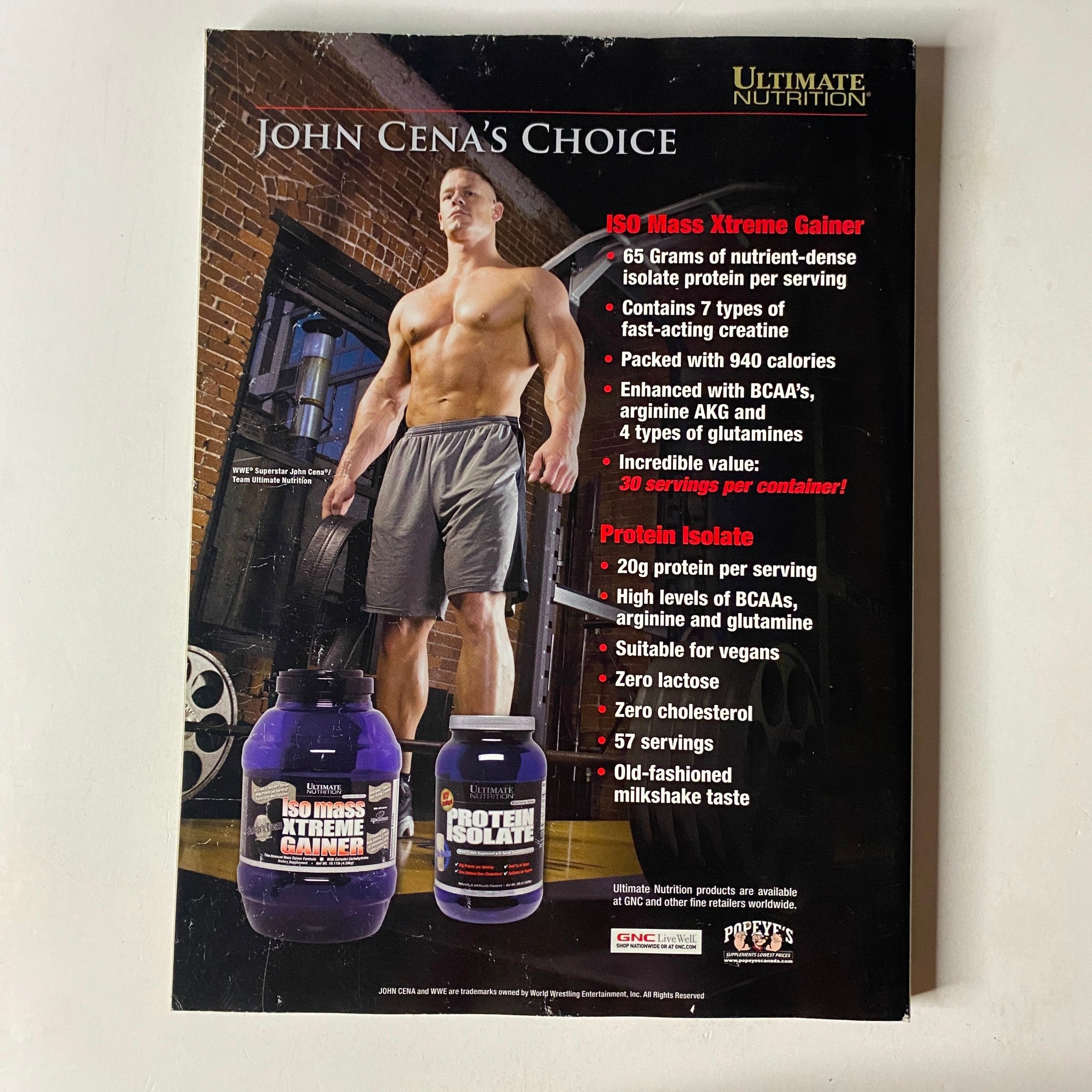 MuscleMag International Magazine April 2009, Issue No. 323 back cover showcasing 'John Cena's Choice' with product details for ISO-Mass Xtreme Gainer and Protein Isolate.