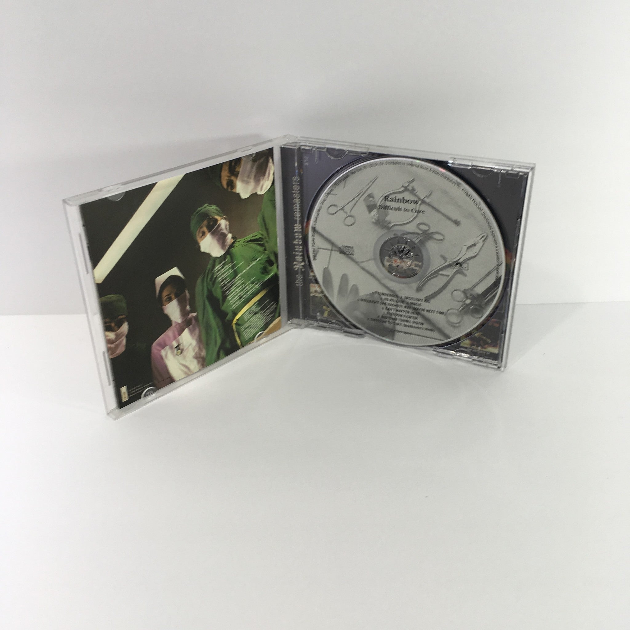 Interior view of Rainbow Difficult To Cure Remasters Music Audio CD showing the disc and artwork, highlighting its collectible nature.